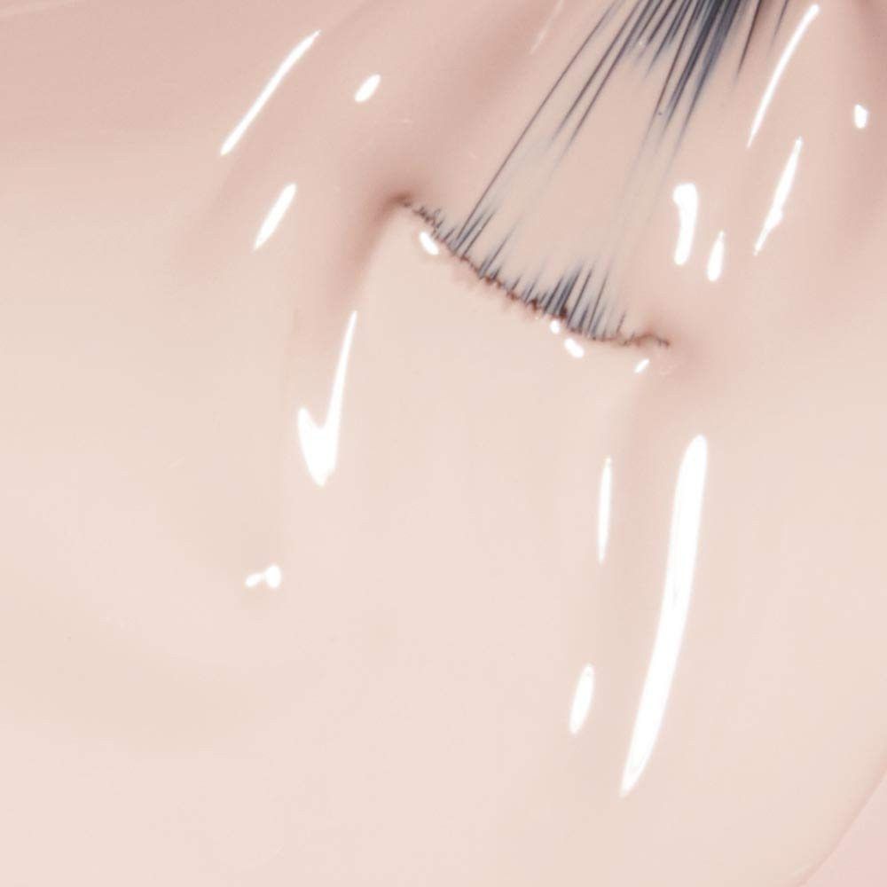 Nahaufnahme eines Pinsels, der Nagellack aufträgt. Farbe: hellrosa. Glänzende Oberfläche.