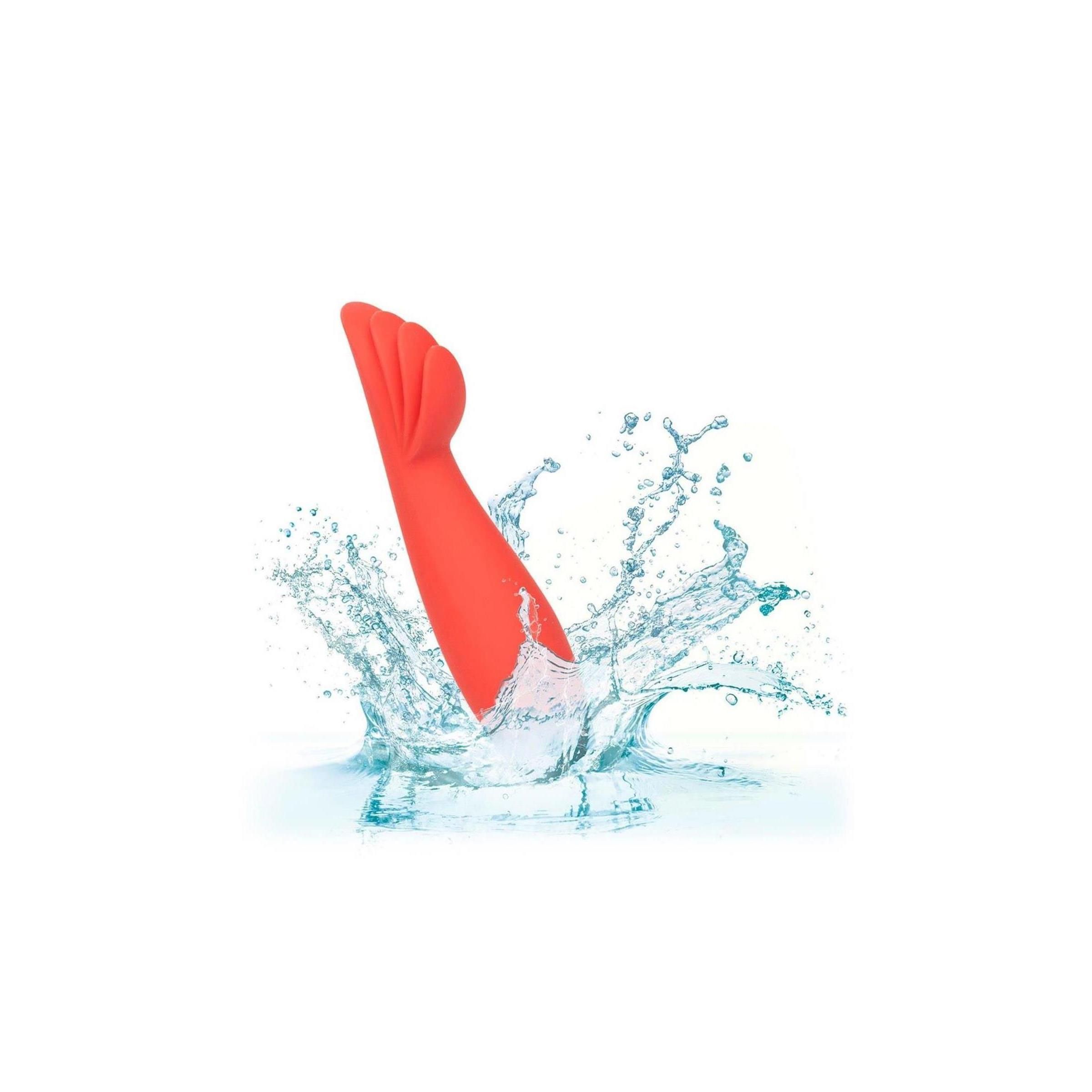 Orangener Vibrator im Wasser. Wasserspritzer umgeben den Vibrator.