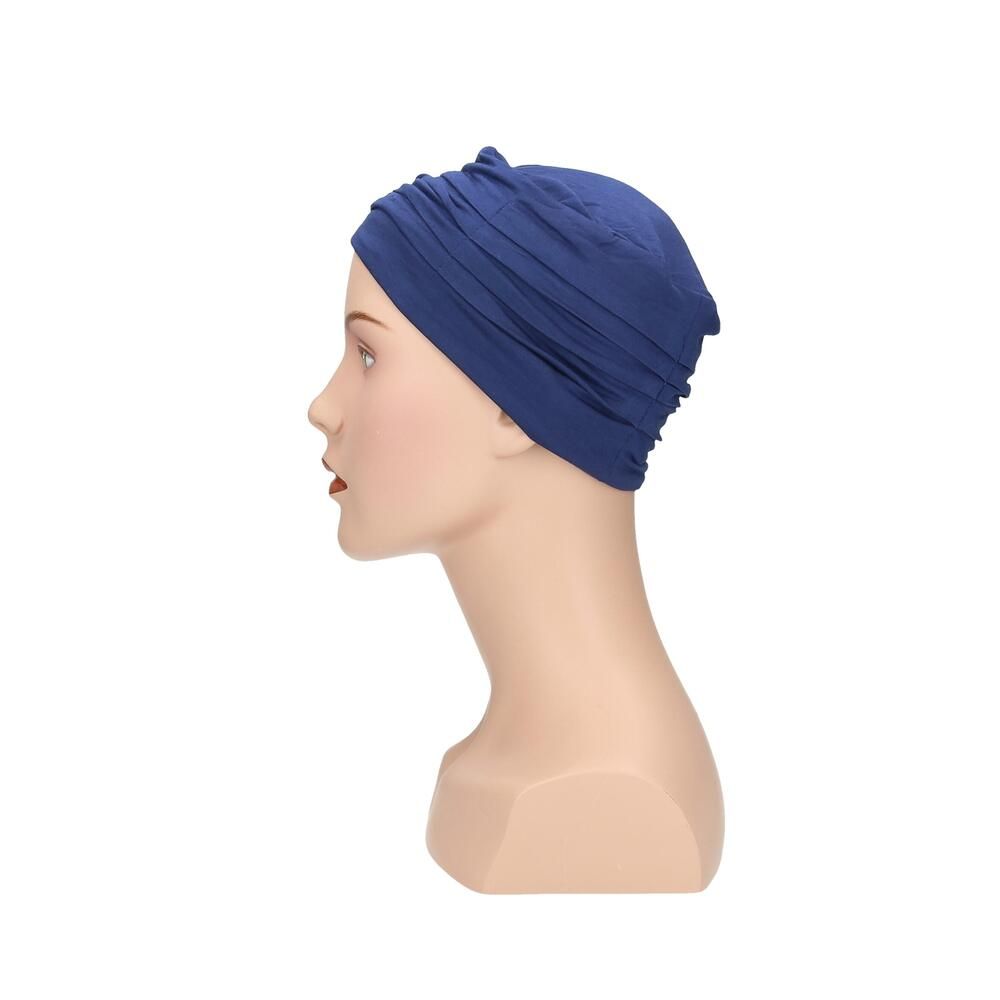 Blauer Turban auf einer Büste. Seitenansicht. Stoff mit Falten. Keine weiteren Details.