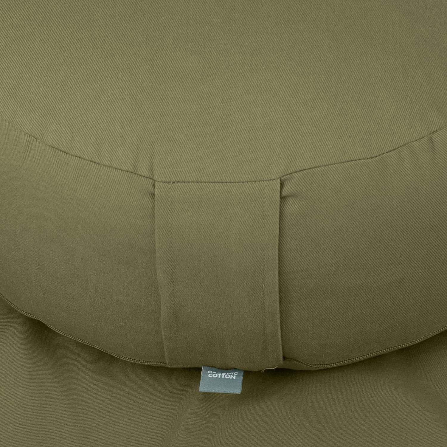 Nahaufnahme des grünen Meditationskissens RONDO ECO. Stoff mit eingenähtem Band und Etikett.