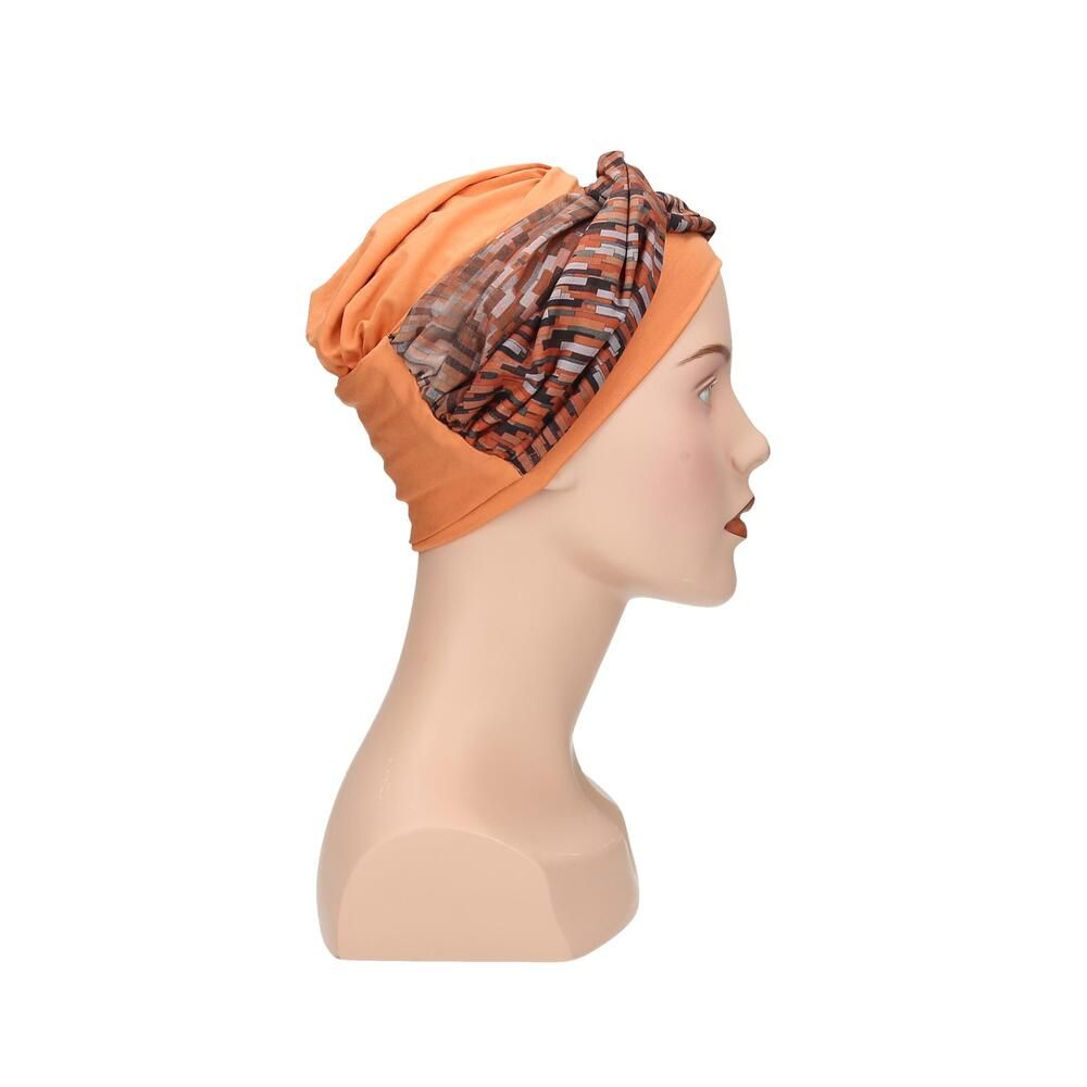 Turban mit orangefarbenem Unterteil und gemustertem Oberteil. Auf einer Schaufensterpuppe, Seitenansicht.