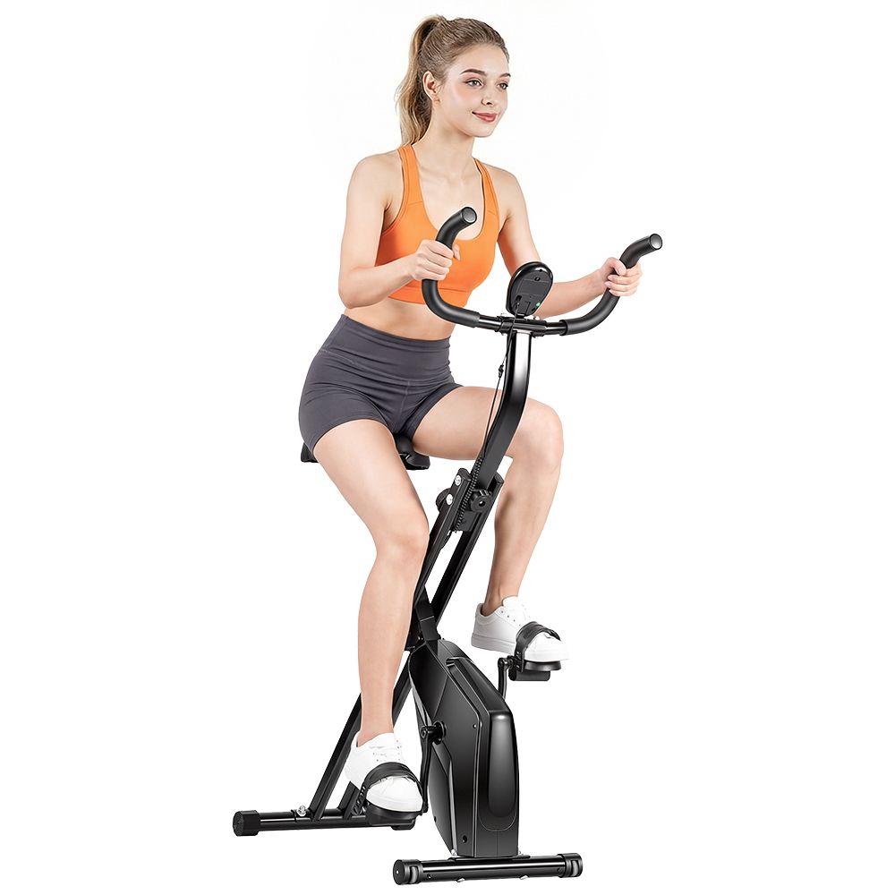 Frau auf schwarzem, klappbarem Heimtrainer-Fahrrad. Sie trägt Sportkleidung. Das Fahrrad hat einen Display.