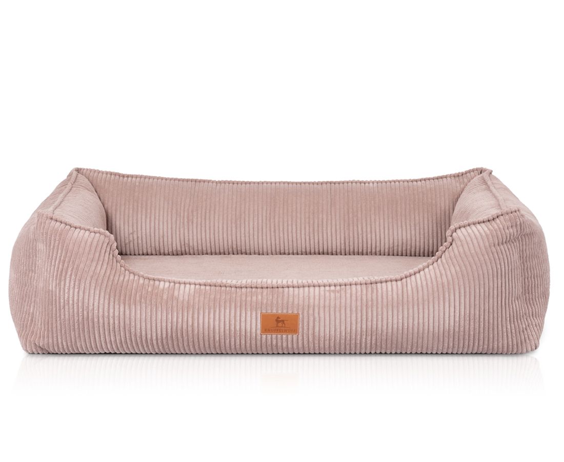 Orthopädisches Hundebett, rosa, Cord-Optik, rechteckig mit erhöhten Seiten. Kleines Label. Auf hellem Hintergrund.