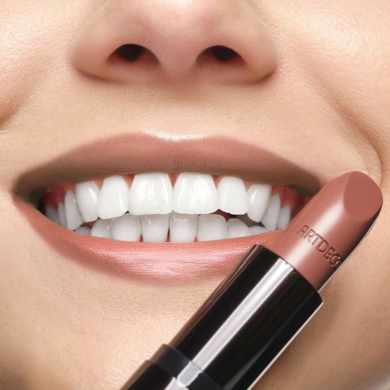 Person mit geöffnetem Mund und Lippenstift. Lippenstift mit Aufschrift Artdeco.