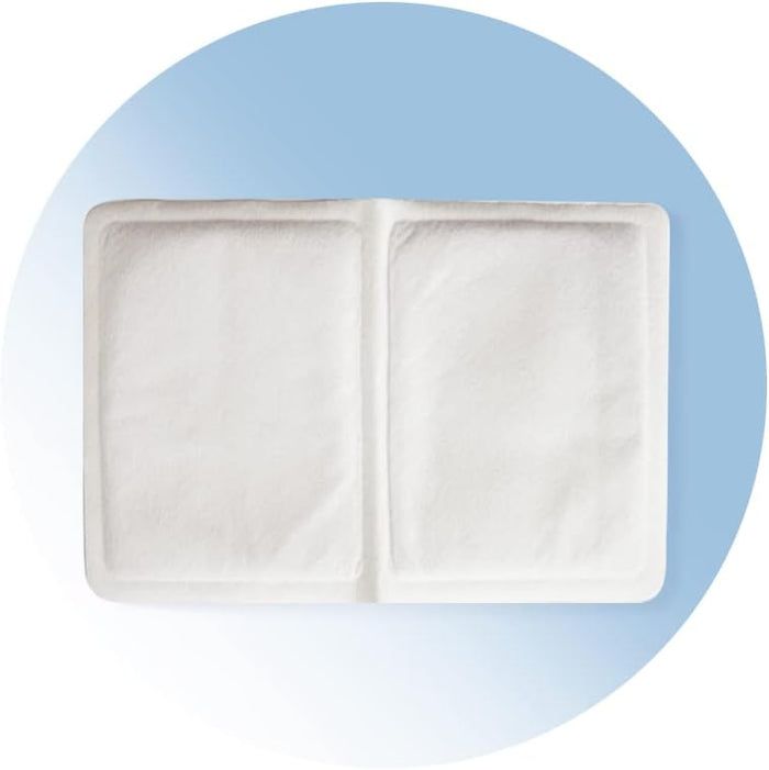 Twee vierkante warmtepleisters naast elkaar. Wit, textiel materiaal. Blauwe achtergrond met witte cirkel.