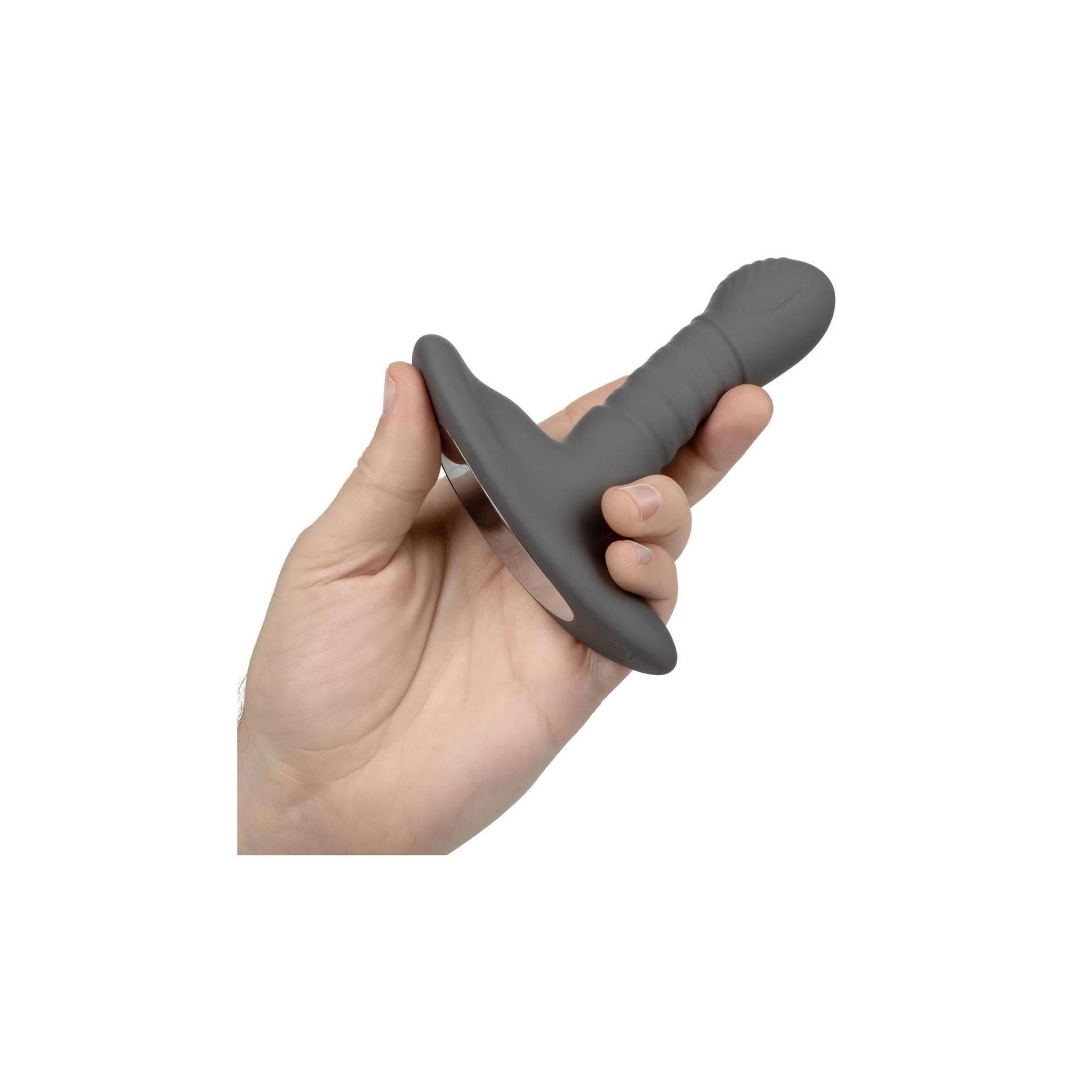 Hand hält einen grauen Anal-Stimulator. Auf weißem Hintergrund.