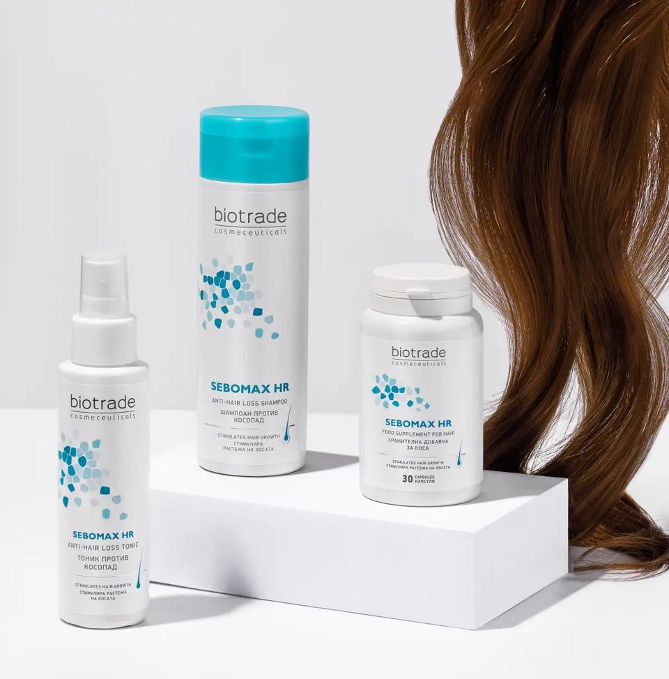 Drei Biotrade Produkte: Shampoo, Spray und Tabletten. Text: Sebomax HR. Weiße Flaschen und Dose. Braunes Haar im Hintergrund.