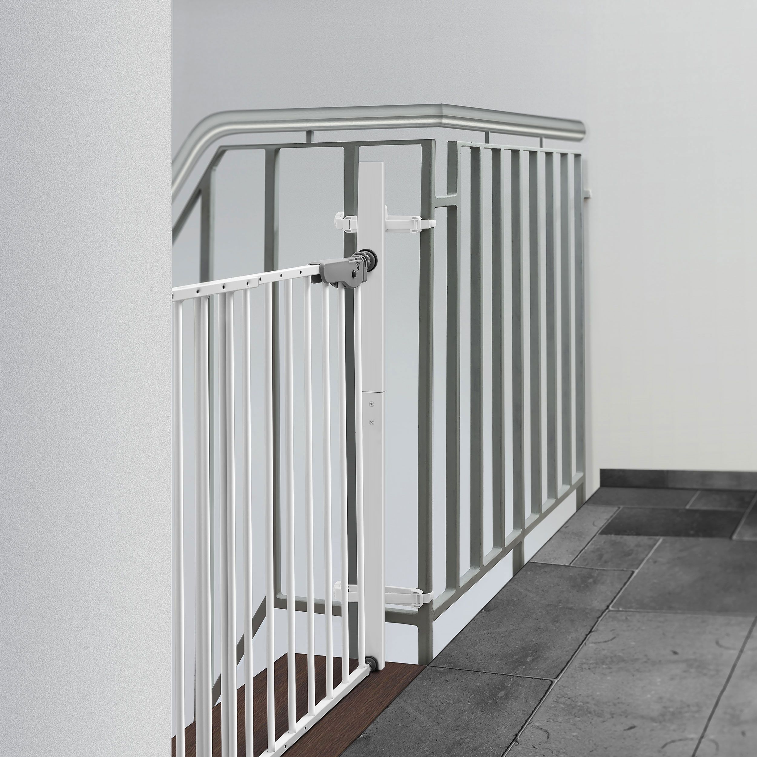 Weißes Treppengitter an einer Treppe. Graue und weiße Elemente. Metallgeländer. Grauer Boden.