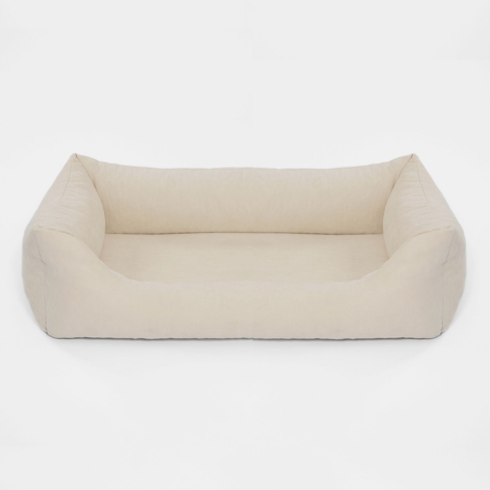 Beigefarbenes Hundebett mit rechteckiger Form und erhöhten Seiten. Auf hellem Hintergrund.