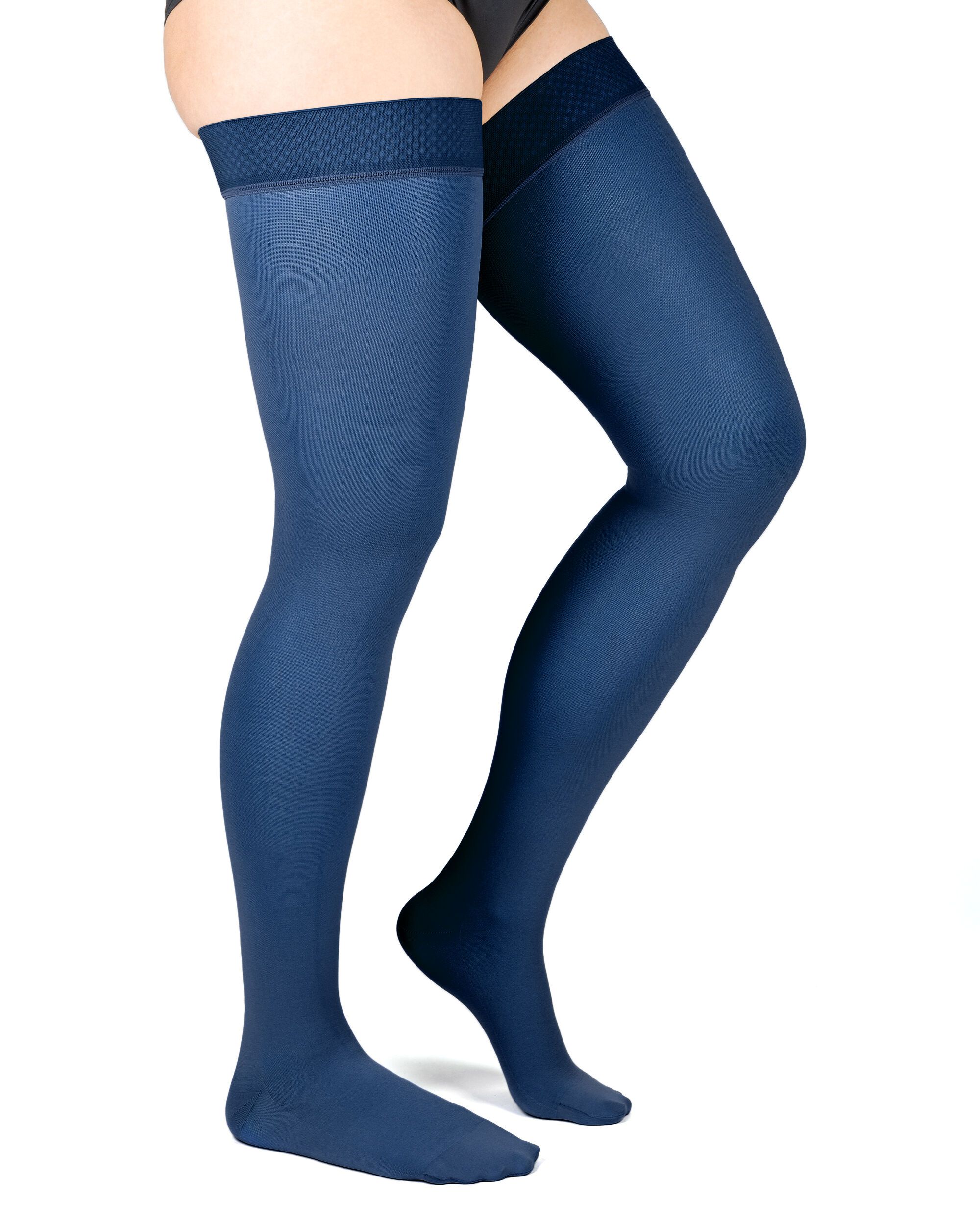 Oberschenkelstrümpfe, marineblau. Mit strukturiertem Abschlussband. Blick von der Seite, Beine einer Person.