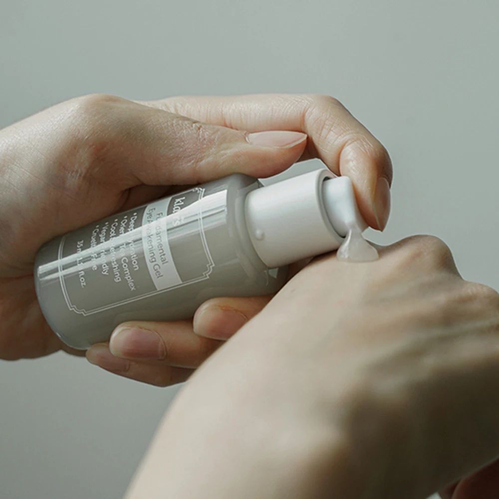 Hände halten eine Tube. Gel wird aus der Tube auf die Handfläche gedrückt. Produktname sichtbar.