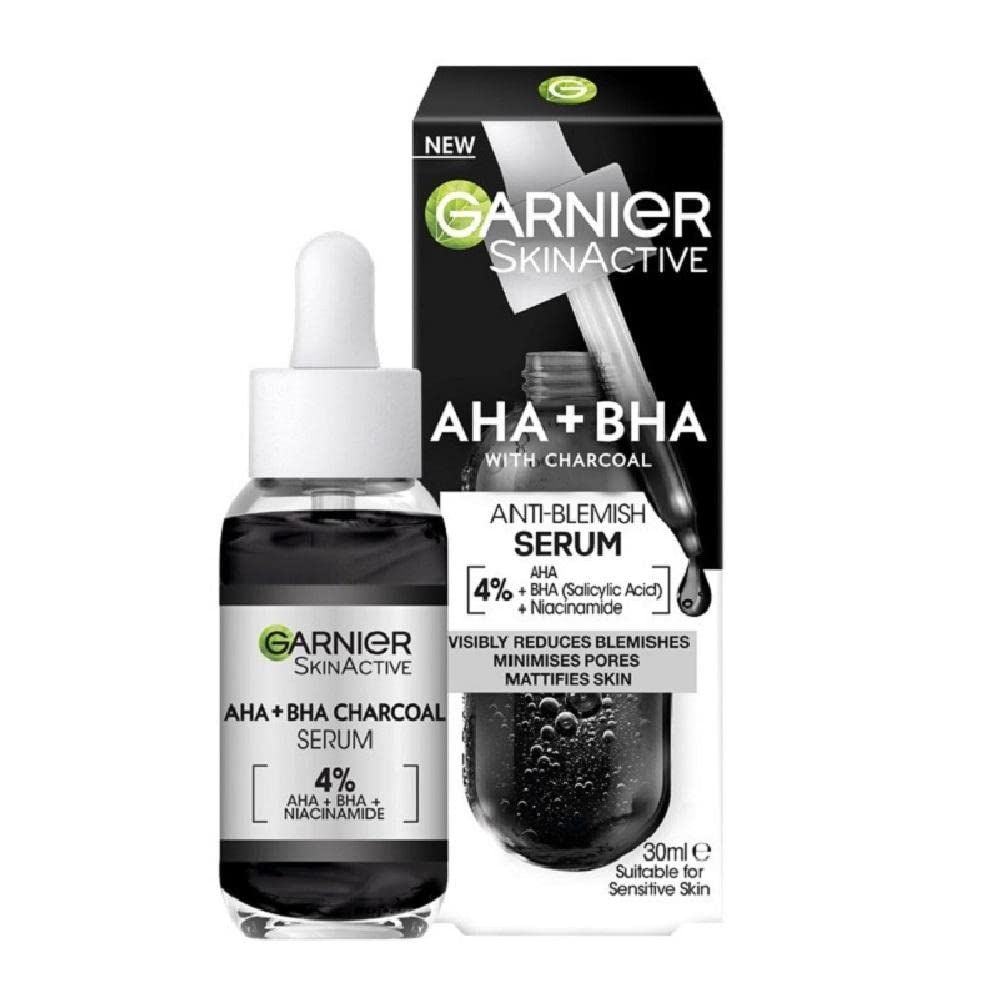 Serumflasche mit Pipette und Verpackung. Schwarze Flüssigkeit, weiße Pipette. Text: Garnier SkinActive, AHA+BHA Charcoal Serum.