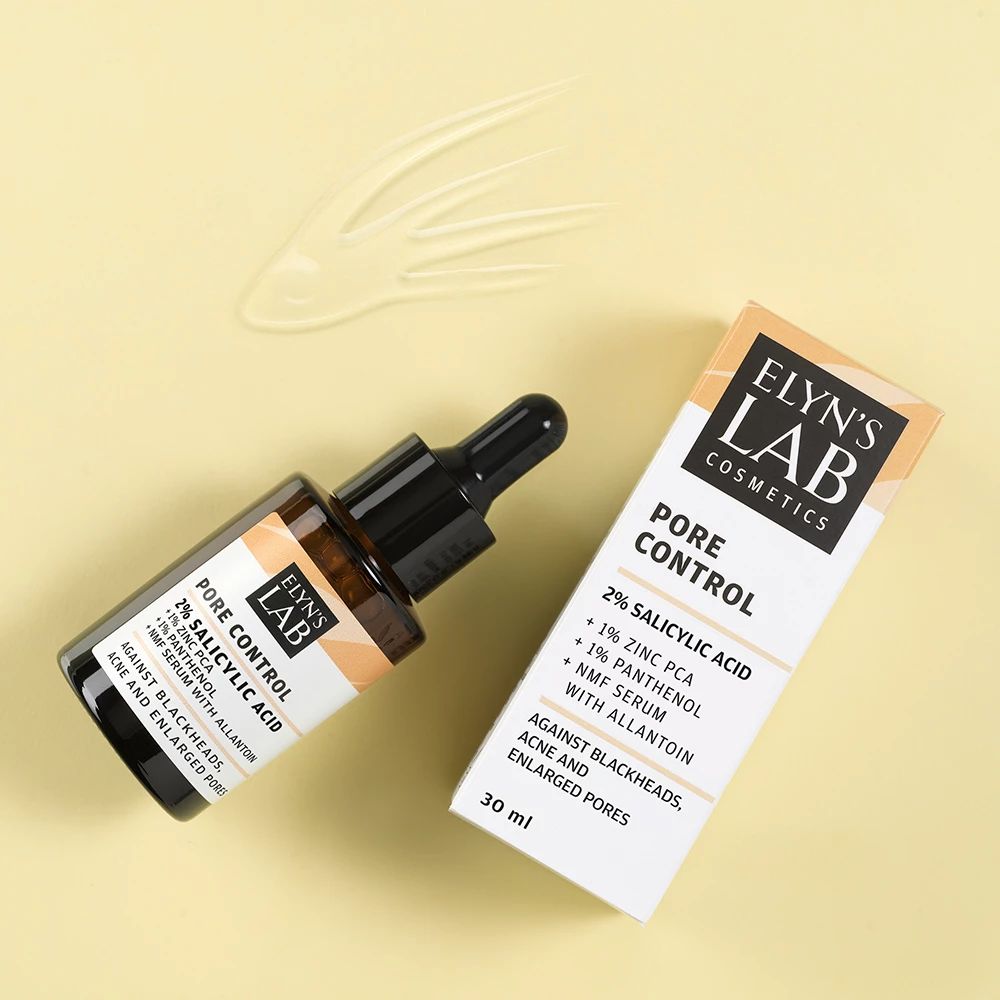 Produktflasche und Verpackung. Flasche mit Pipette, daneben Schachtel. Aufschrift: Pore Control, 2% Salicylsäure, 1% Zink PCA, 1% Panthenol. Gegen Akne.