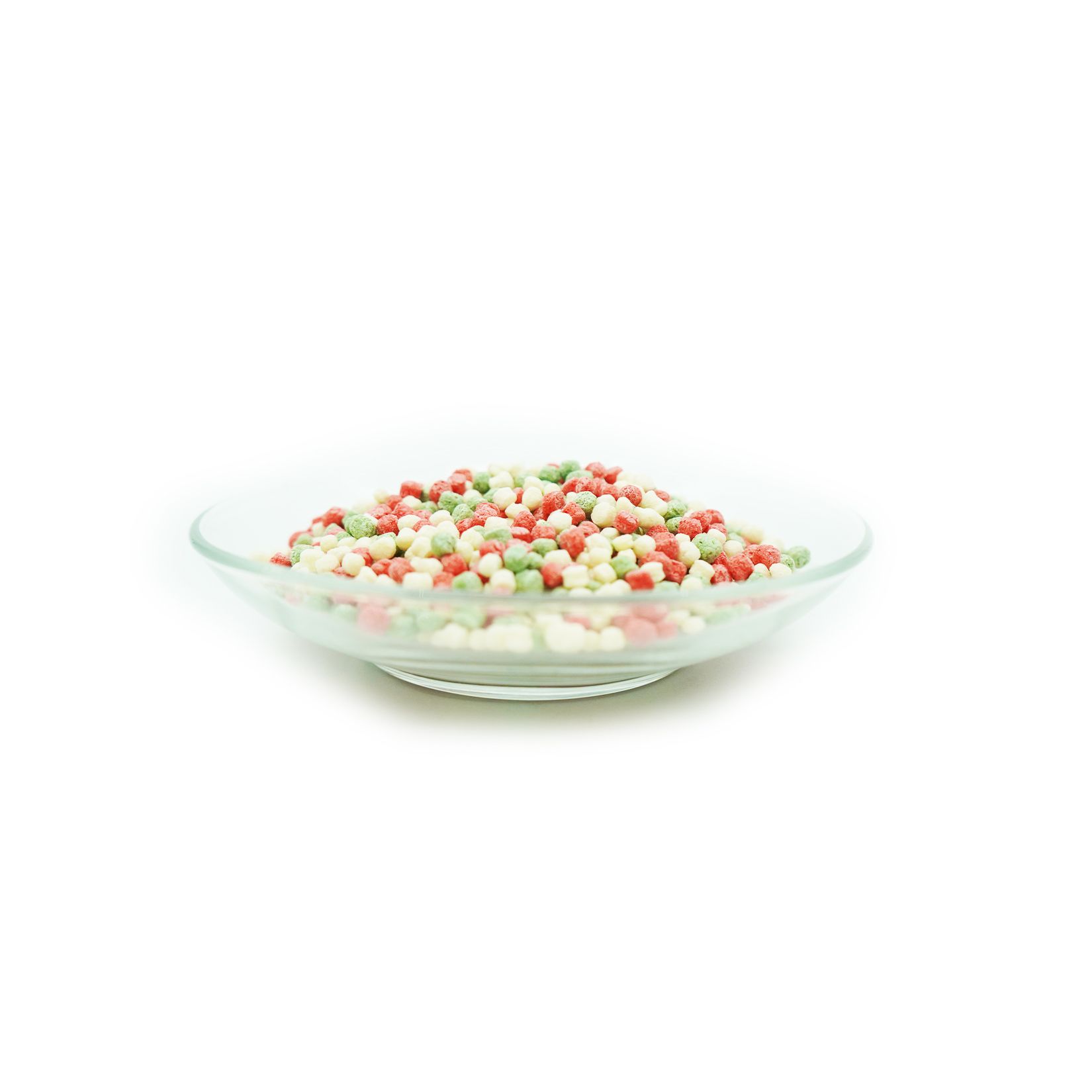 Fischfutter in einer Glasschale. Mehrfarbige, runde Pellets.