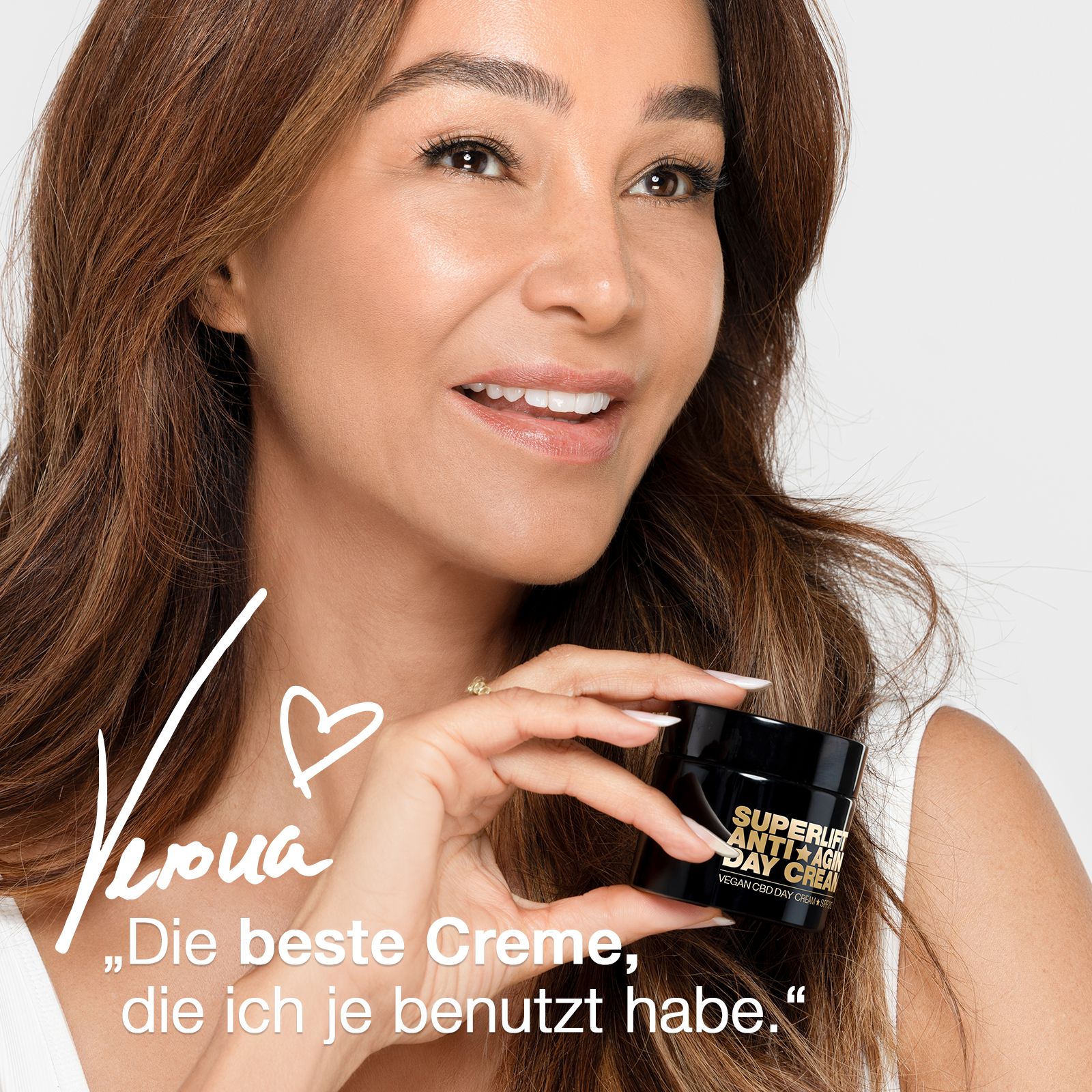 Frau hält eine schwarze Creme-Dose. Auf der Dose steht "SUPERLIFT ANTI-AGING DAY CREAM". Text: "Die beste Creme, die ich je benutzt habe."