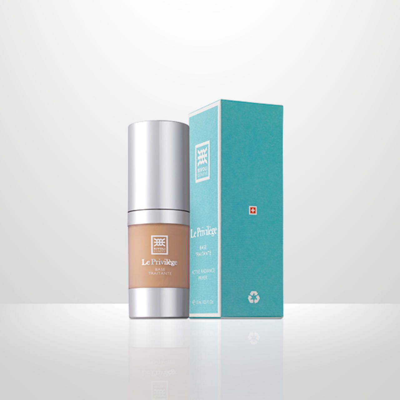 Zylindrische Flasche und Schachtel. Flasche mit silbernem Deckel, rosa Etikett. Schachtel blau mit Logo und Text.