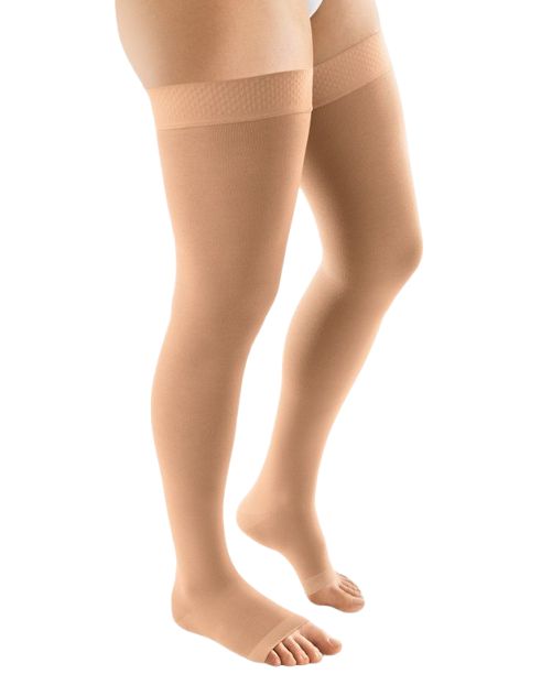 Hautfarbene Kompressions-Schenkelstrümpfe mit offener Fußspitze. Feines, strukturiertes Bündchen.