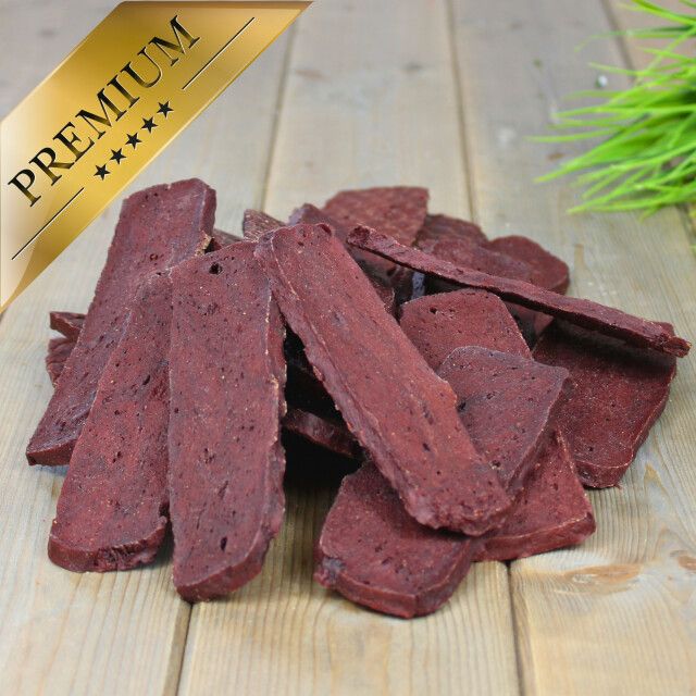 Lammfleischstreifen auf Holzuntergrund, goldfarbenes Premium-Etikett.