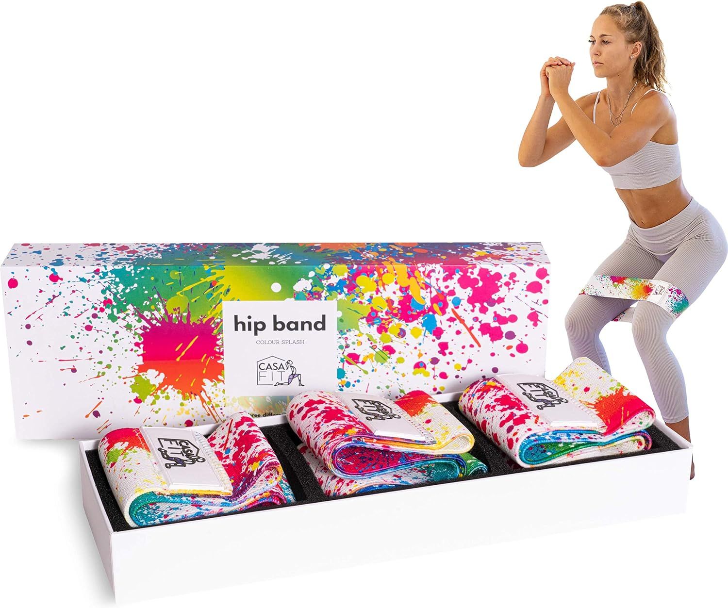 Produktverpackung mit drei Hüftbändern. Farbspritzer-Design. Frau macht Kniebeugen. Weißer Karton mit Produktnamen.