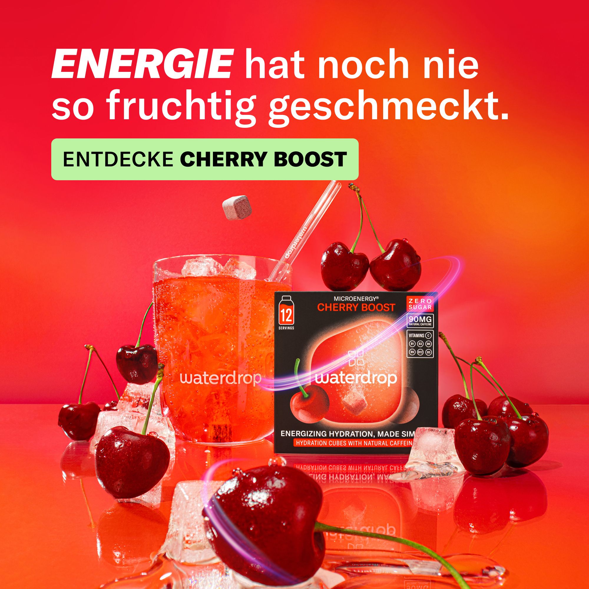 Eine Packung Kirsch-Boost-Würfel, Kirschen, Eiswürfel und ein Glas Getränk. Text: Entdecke Cherry Boost. Auf der Packung steht '12'.