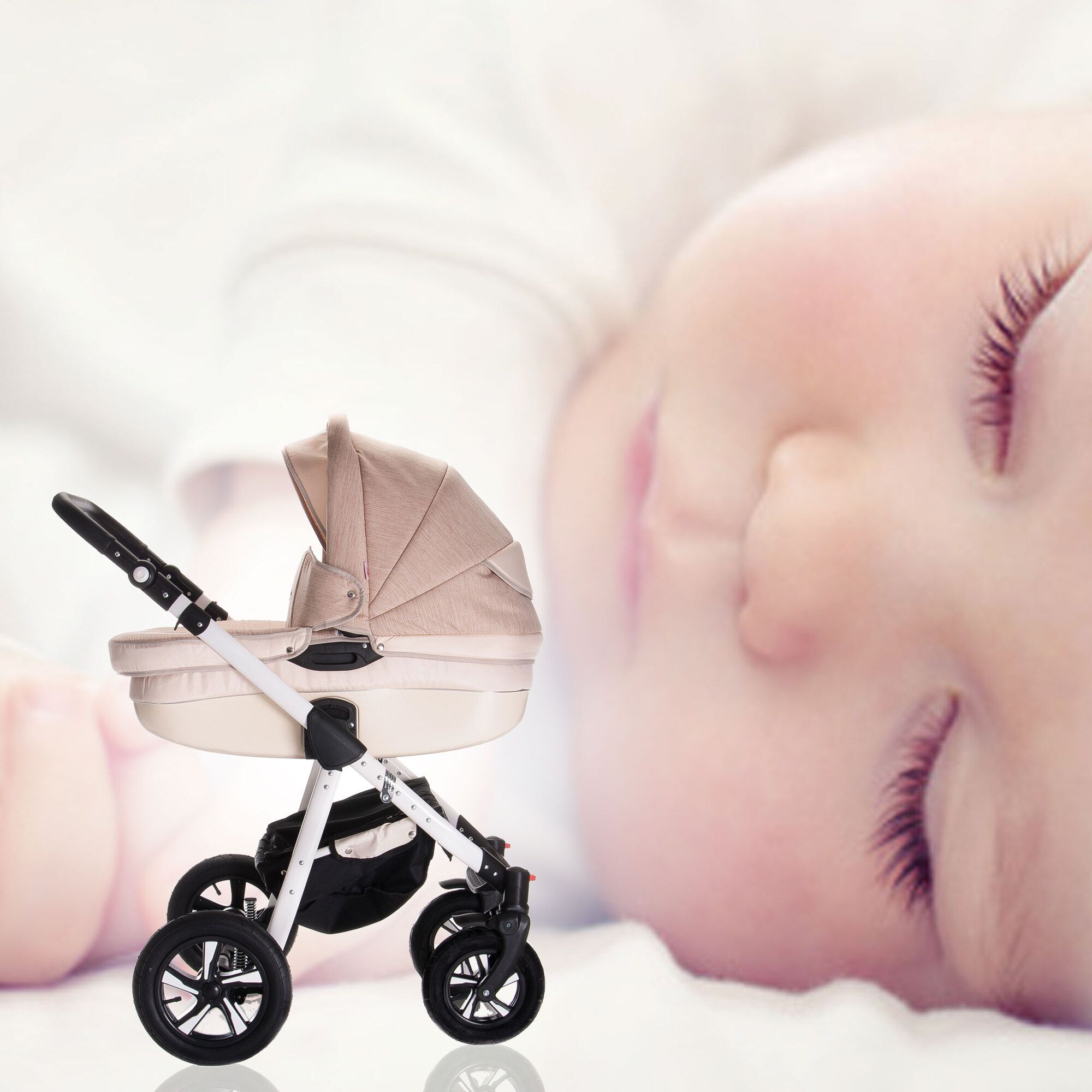 Kinderwagen in Cappuccino-Farbe neben einem schlafenden Baby. Der Kinderwagen hat ein Verdeck und Hartgummireifen.