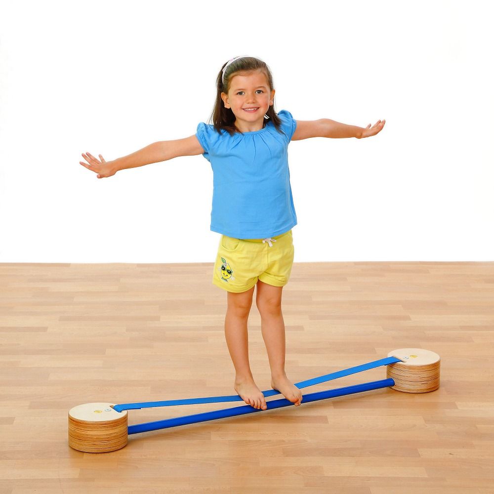 Kind balanciert auf Slackspot. Holzscheiben mit blauen Bändern. Kind trägt gelbe Shorts und blaues T-Shirt.