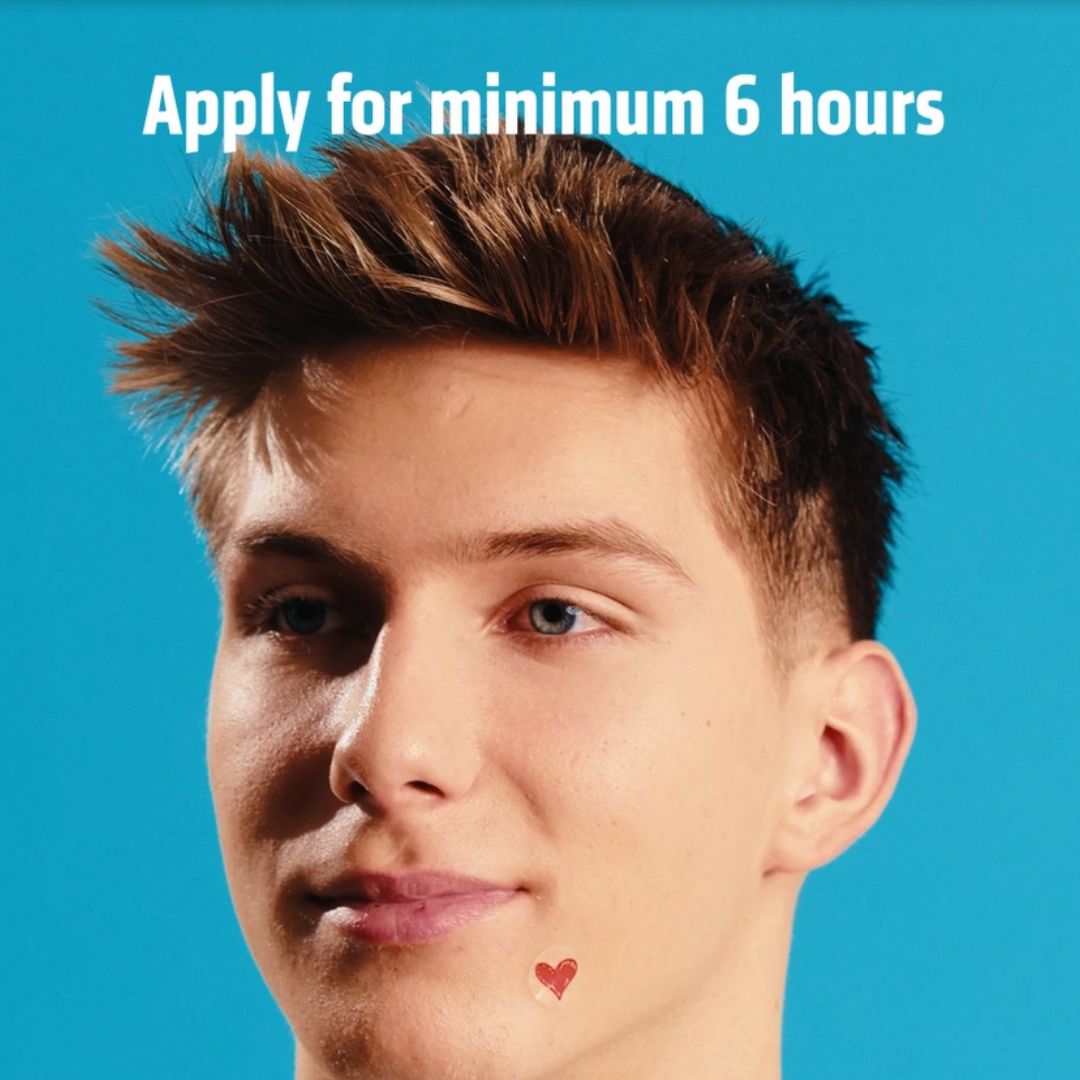 Junger Mann mit Herz-Patch auf der Wange. Text: Apply for minimum 6 hours.