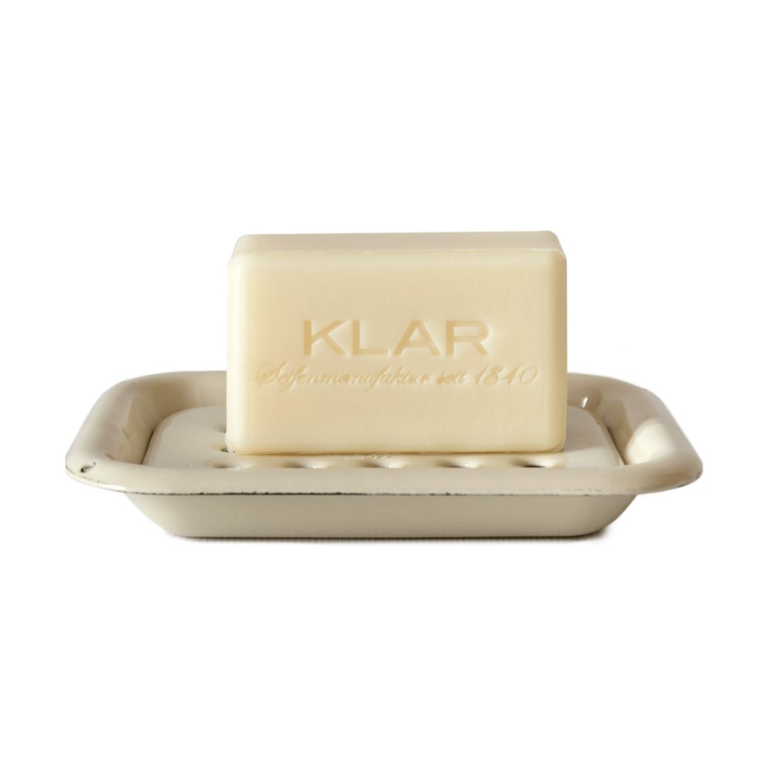 Savon crème sur porte-savon émaillé avec logo Klar. Forme rectangulaire, trous dans le support.