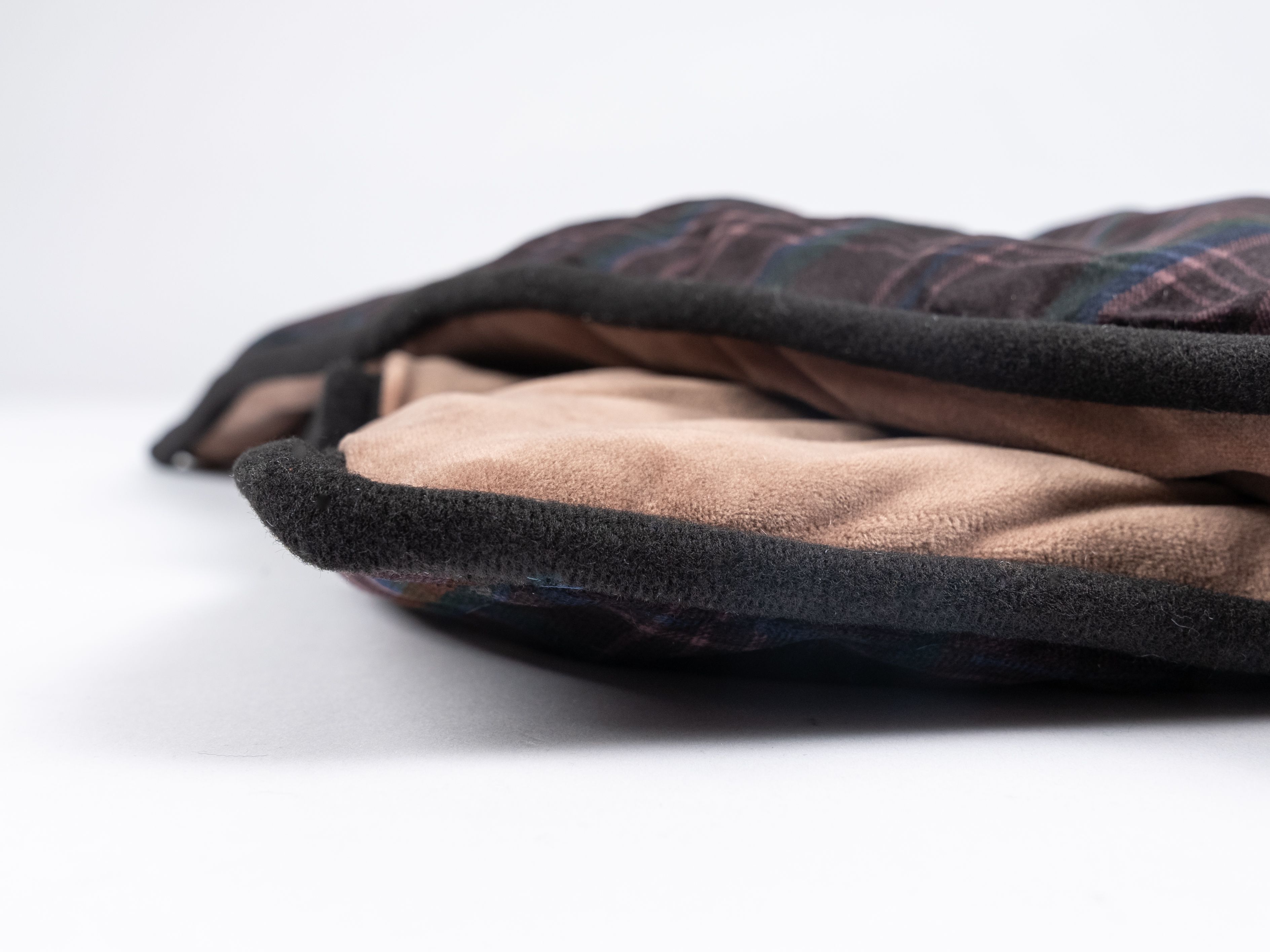 Nahaufnahme der Decke. Oben braun-kariert, unten braun. Schwarzer Rand.