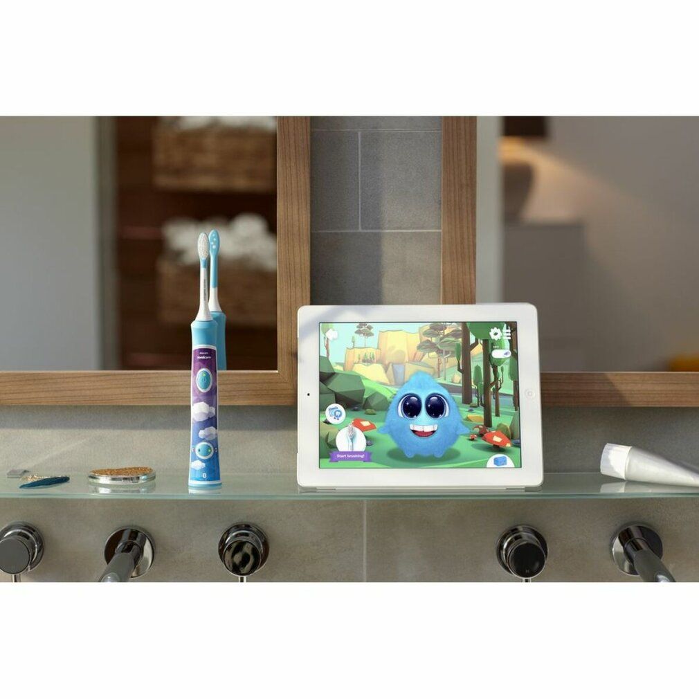 Zahnbürste und Tablet auf Ablage. Tablet zeigt Spiel. Philips Sonicare for Kids Zahnbürste.