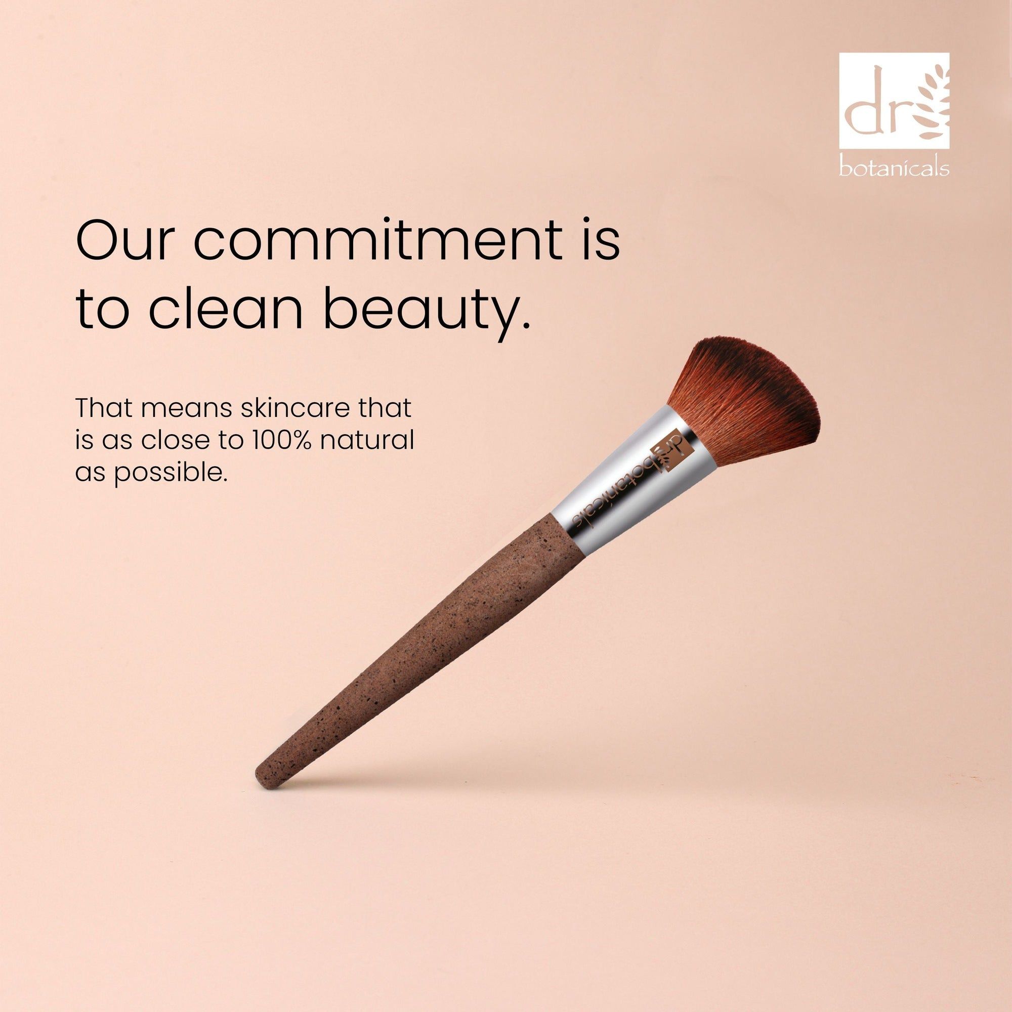 Pinsel mit braunen Borsten und Korkgriff. Metallhülse. Text: Our commitment is to clean beauty.