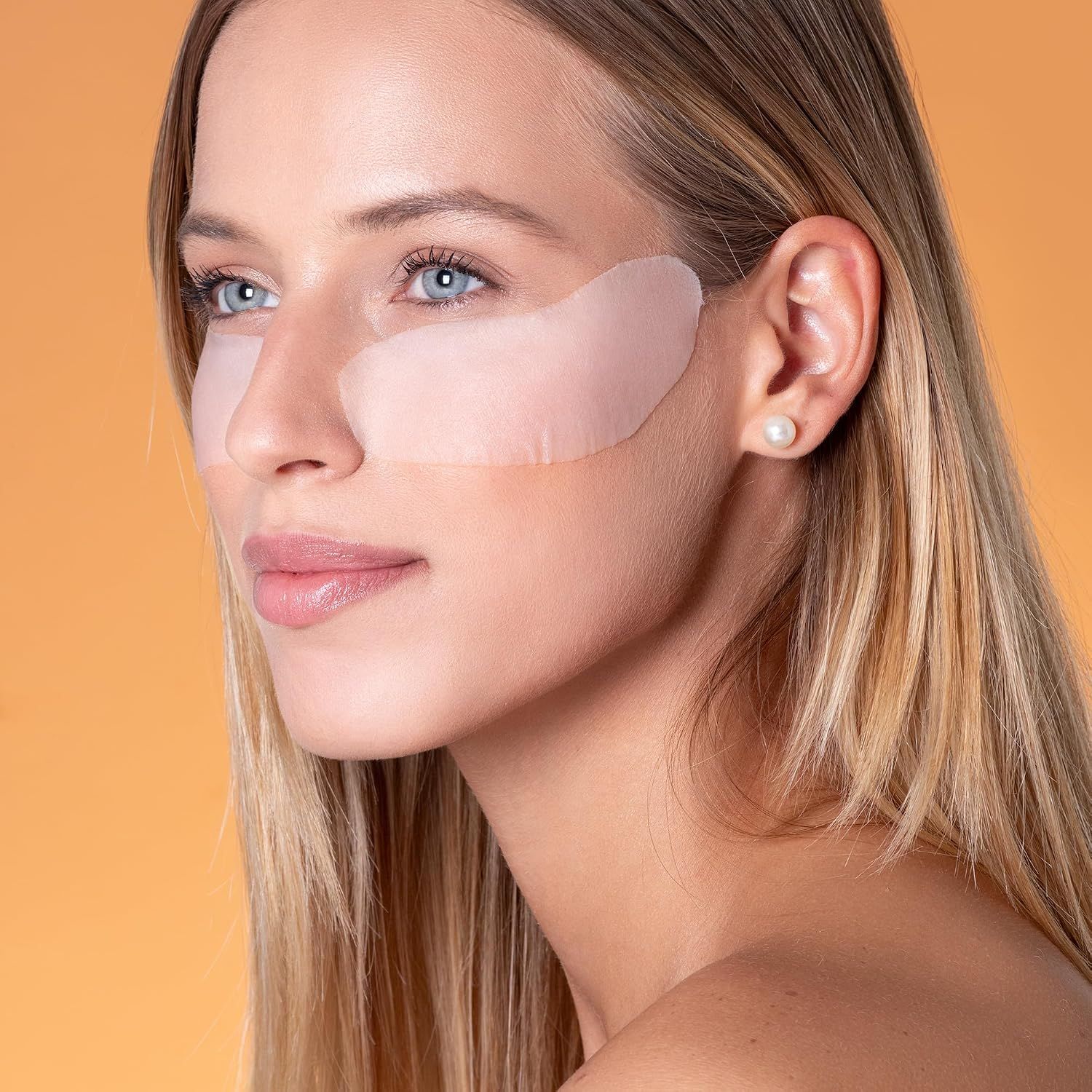 Frau mit blauen Augen und Augenpads unter den Augen.