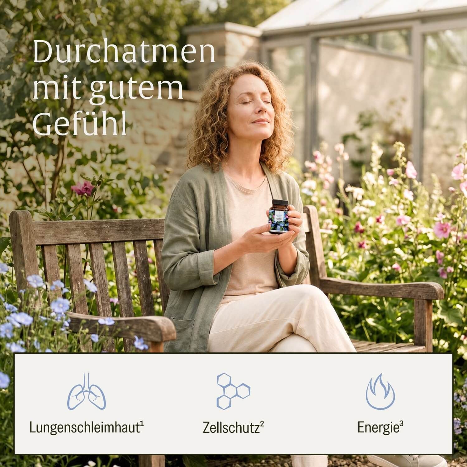 Frau sitzt auf einer Bank im Garten und hält eine Flasche Atem Komplex Lungenkraut.