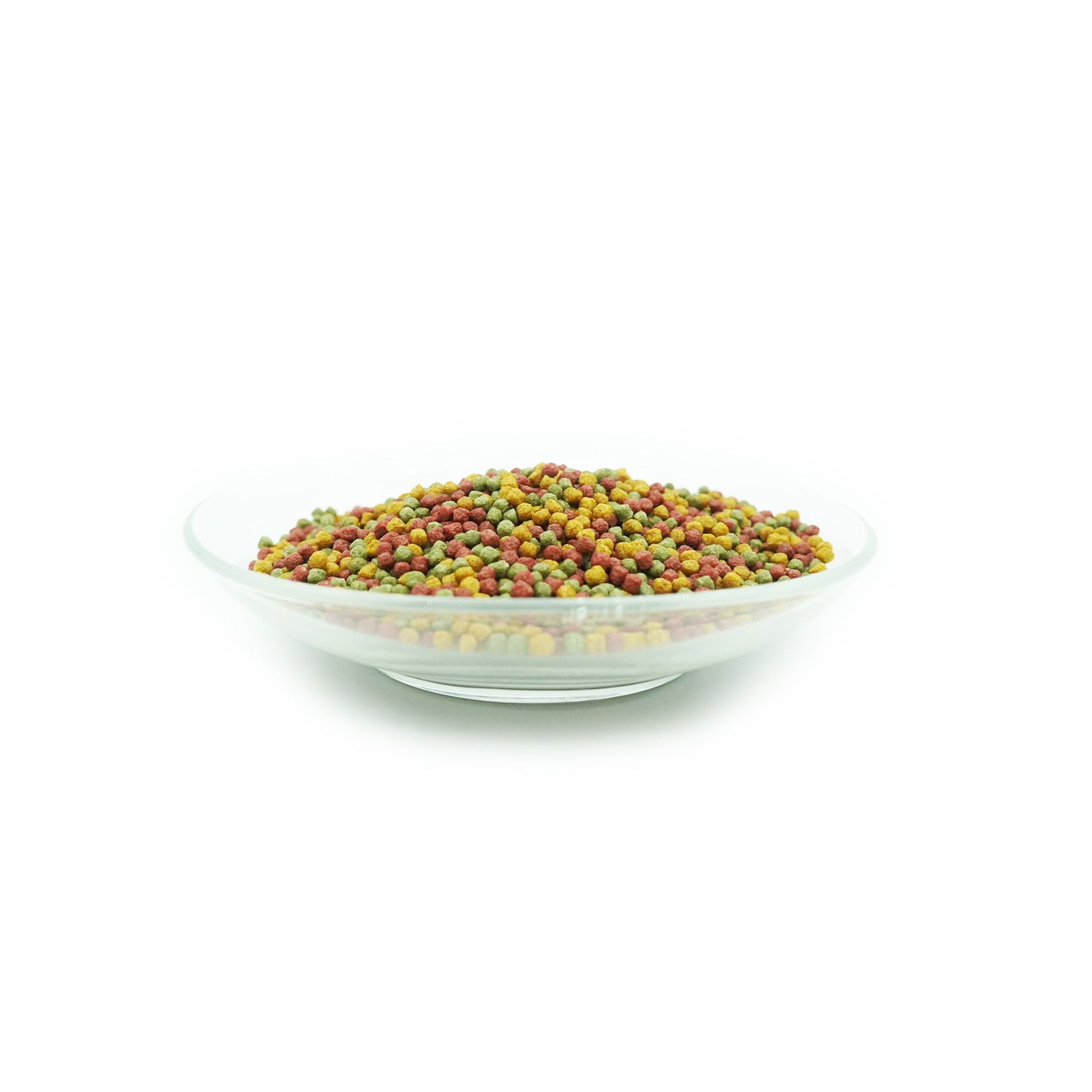Klare Glasschale mit bunten Fischfutter-Pellets. Verschiedene Farben: grün, gelb, rot.