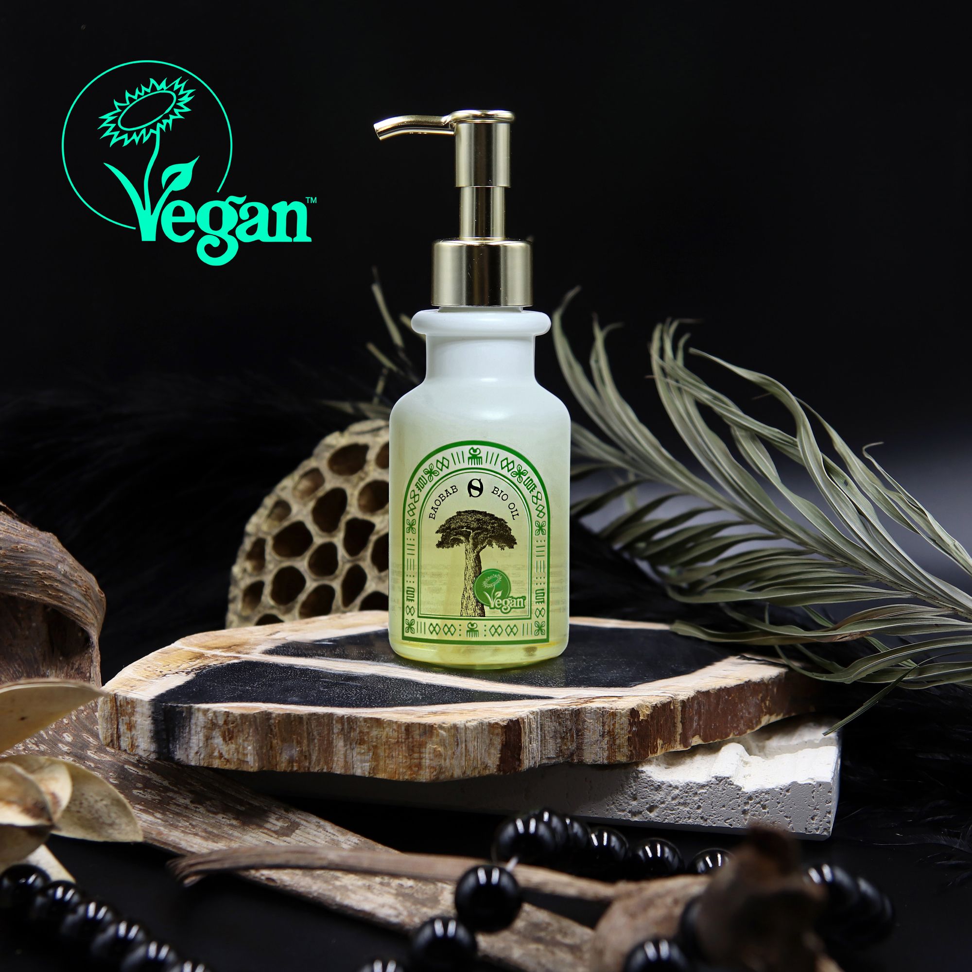 Flacone Onesee Baobab Bio Oil con pompa. Sigillo vegano. Su una tavola di legno. Decorazioni: foglie, perle.