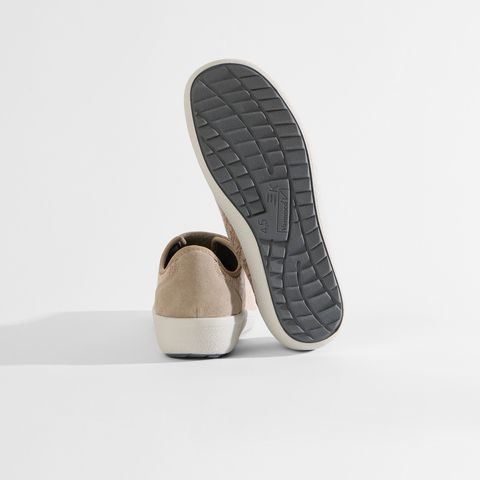 Beigefarbene Damenschuhe mit Klettverschluss und dezentem Muster.