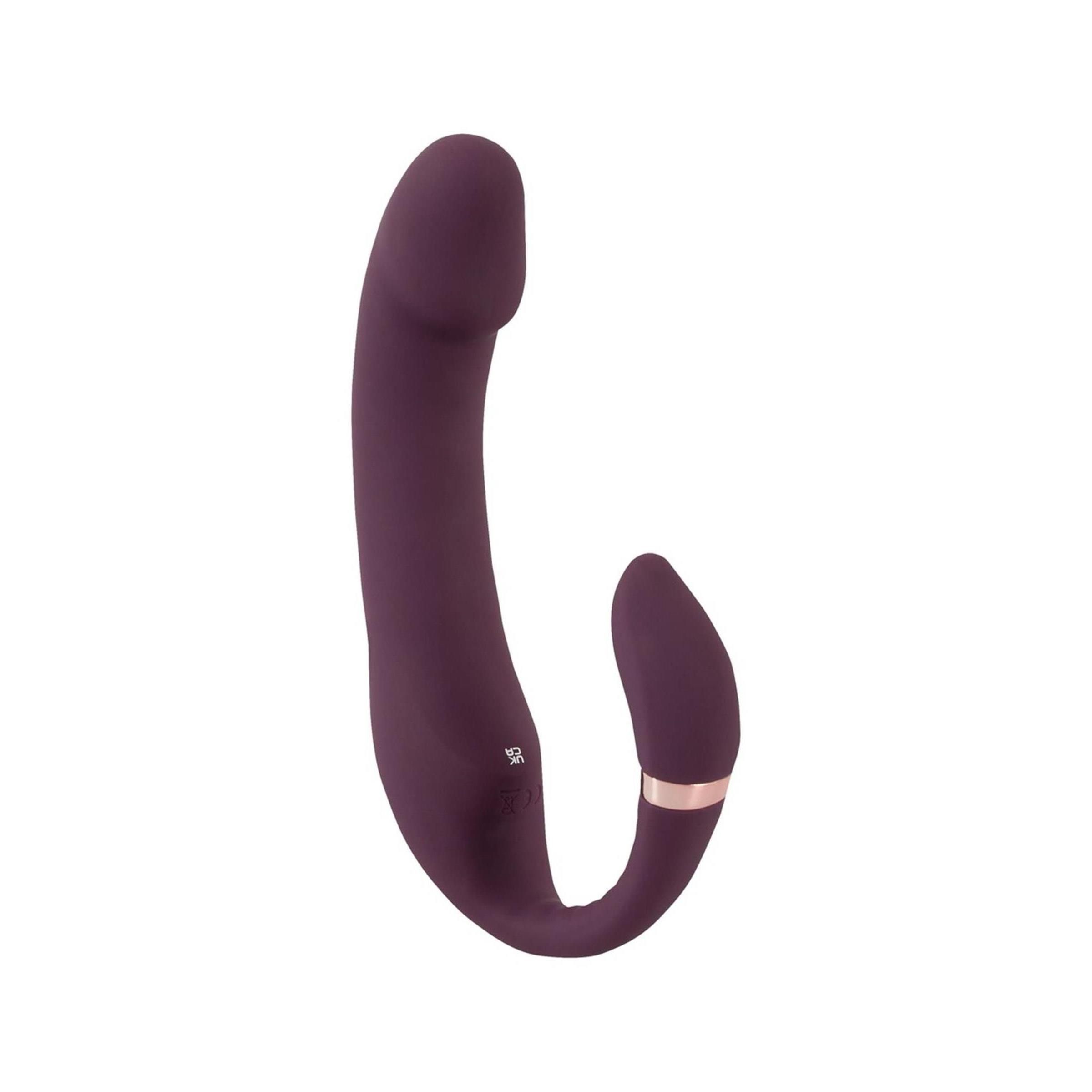 Lila Vibrator mit gebogener Form. Mit einem Stimulator-Aufsatz und einem goldenen Ring. Auf weißem Hintergrund.