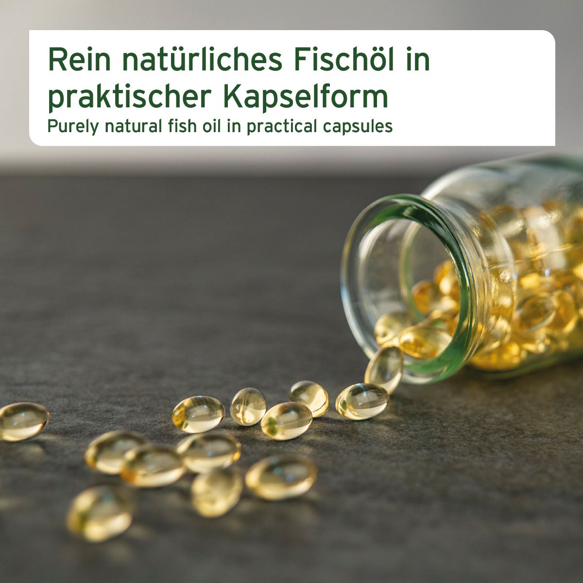 Glasbehälter mit gelben, ovalen Kapseln. Einige Kapseln liegen verstreut auf einer dunklen Oberfläche.