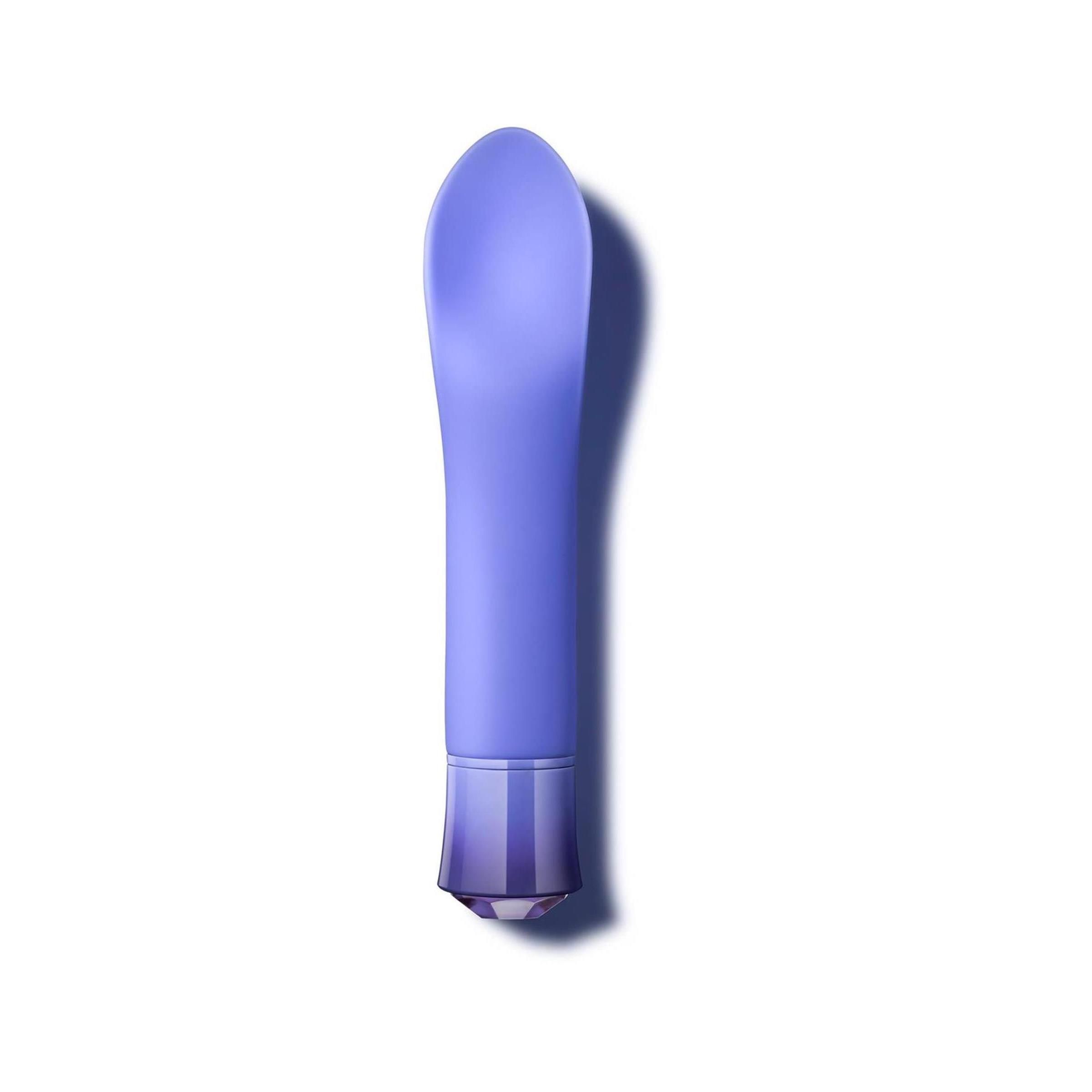Lila Vibrator. Zylindrischer Körper mit abgerundeter Spitze und geriffelter Basis. Unterseite mit geometrischem Muster.
