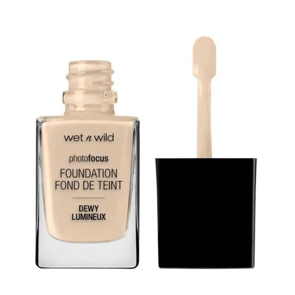 Wet n Wild Photo Focus Foundation. Glasflasche mit hellbeiger Flüssigkeit. Schwarzer Deckel mit Applikator. Text: Dewy Lumineux.