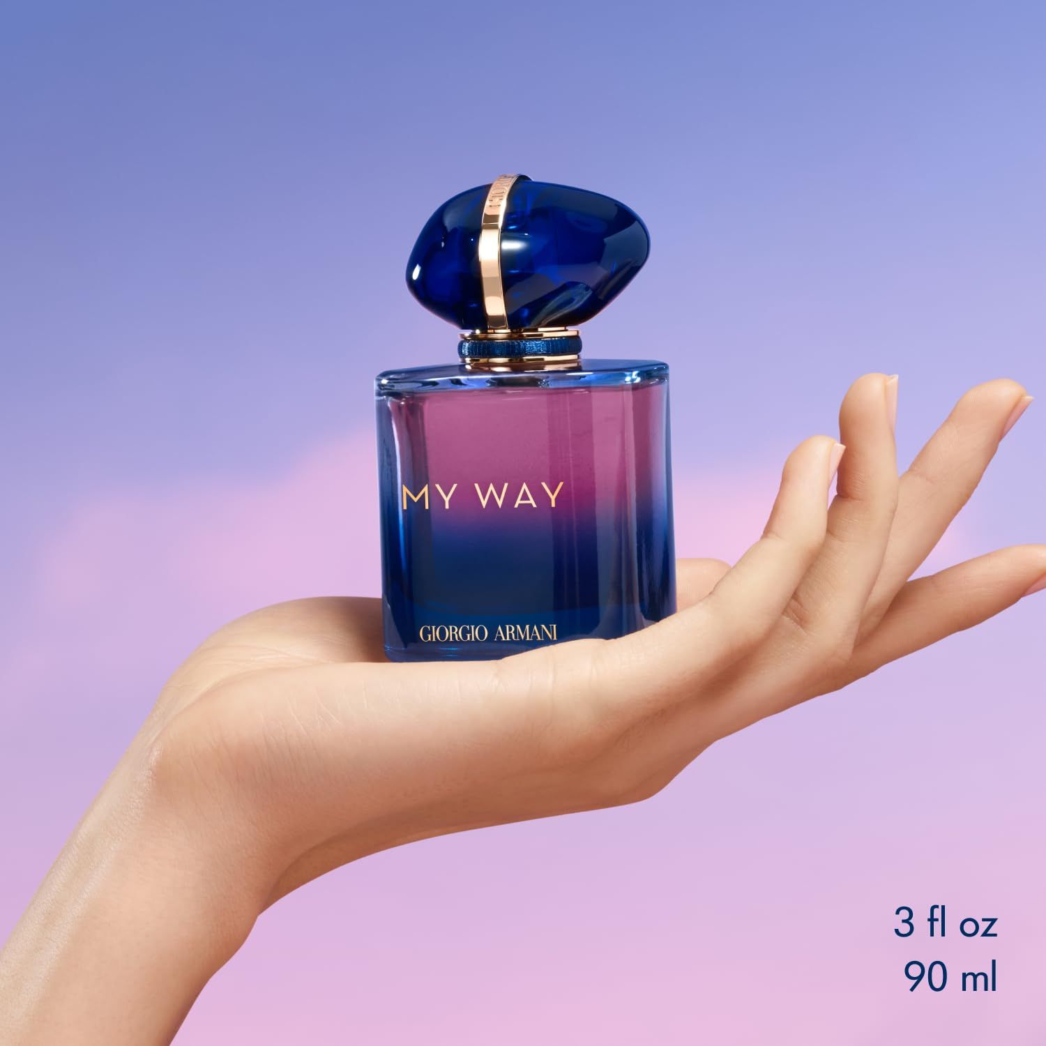 Parfümflakon in einer Hand gehalten. Blaue Kappe, "MY WAY" und "Giorgio Armani" Schriftzug. 90 ml/3 fl oz.