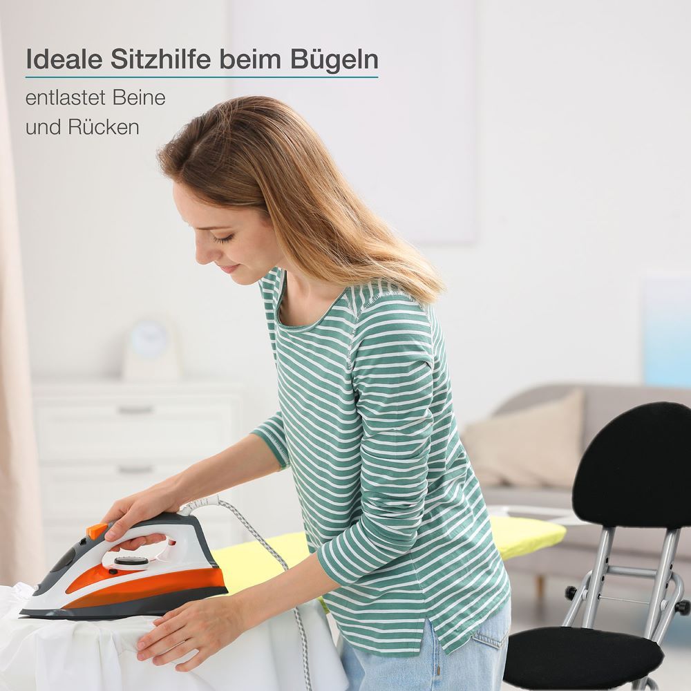 Frau bügelt mit einem Bügeleisen. Daneben steht eine Stehhilfe mit schwarzem Sitz und Rückenlehne.