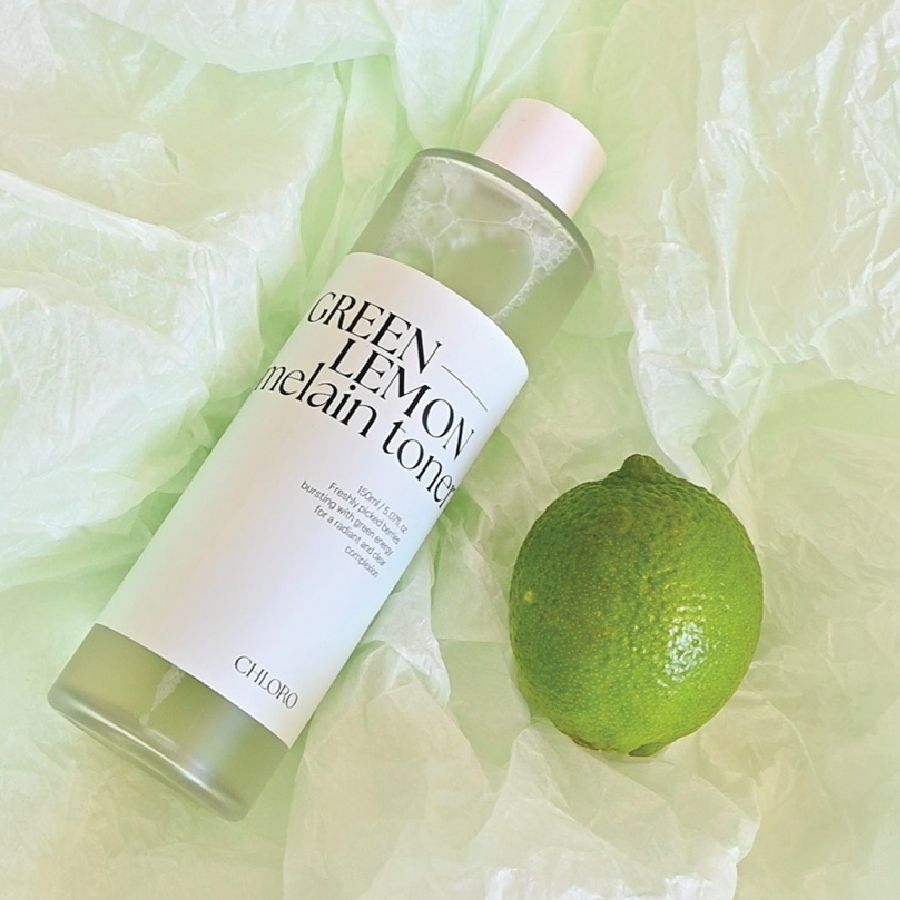 Flasche und Limette auf grünem Papier. Flasche mit Aufschrift: GREEN LEMON melain toner. Limette grün. Marke: CHLORO.