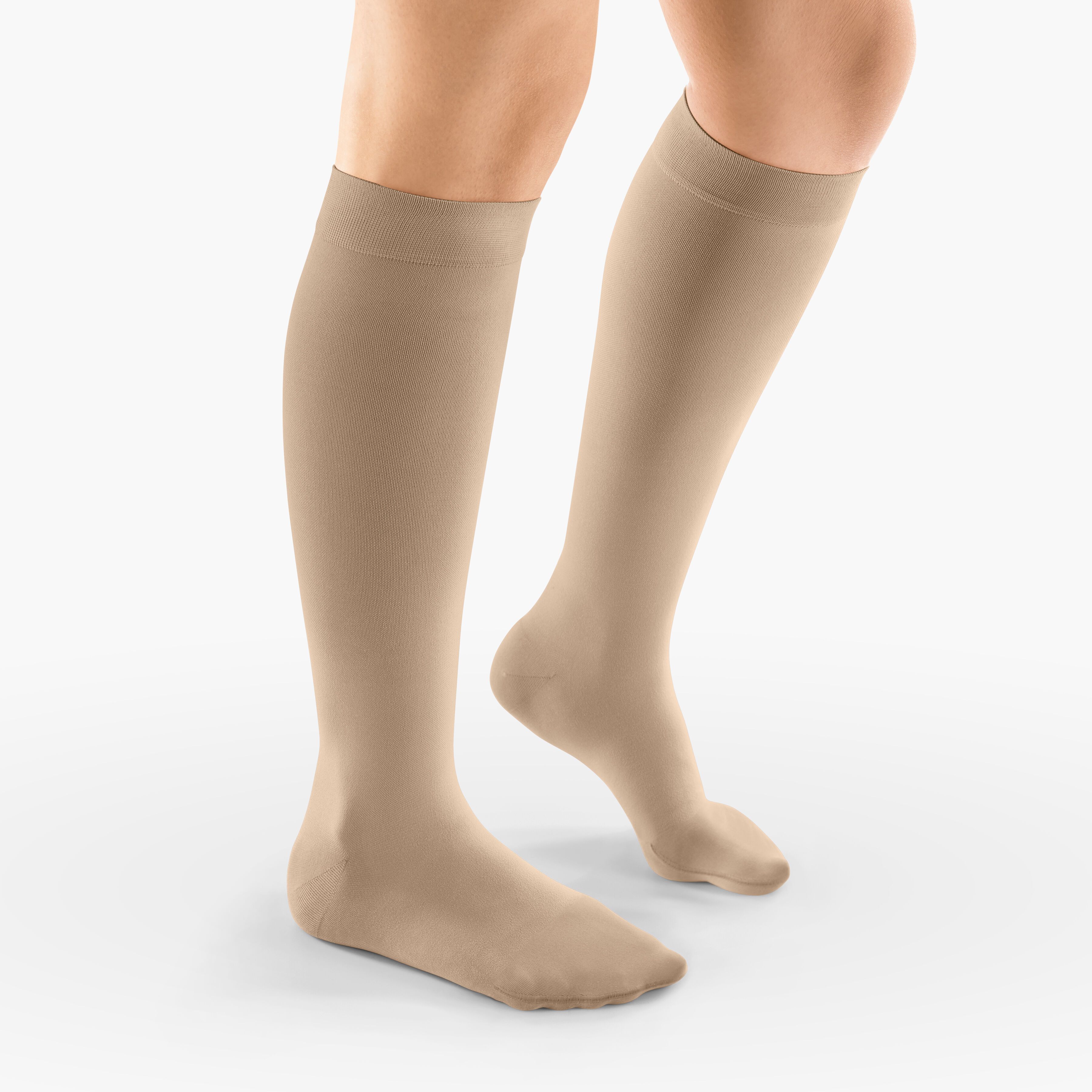 Beige Kompressionsstrümpfe. Kniestrümpfe, aus Stoff, für das Bein. Auf hellem Hintergrund.