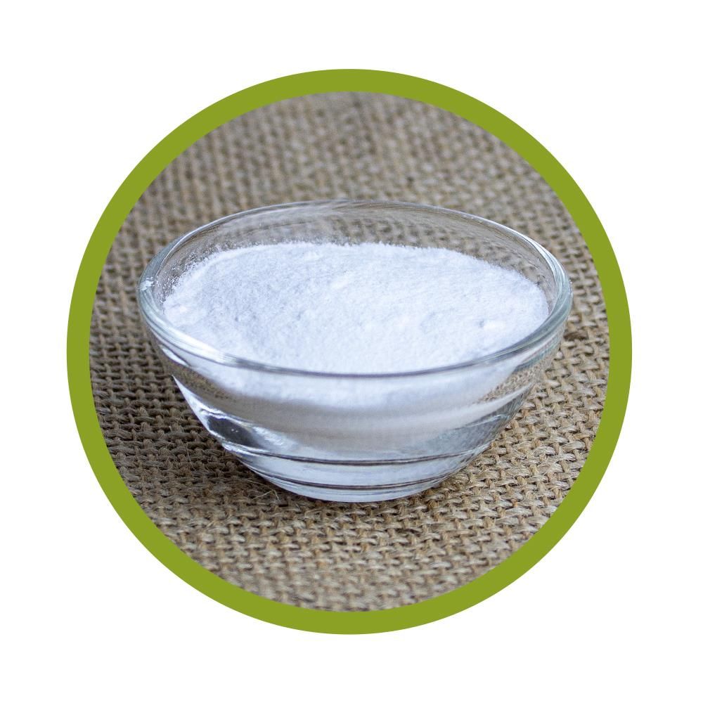 Klare Glasschale mit weißem Pulver. Auf grobem, beigen Stoff platziert. Runde Form, grüne Umrandung.