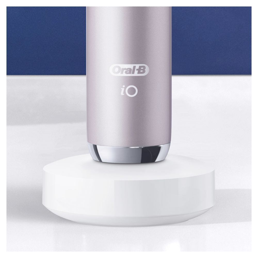 Elektrische Zahnbürste Rose Quartz auf weißer Ladestation. Oral-B iO Logo sichtbar.