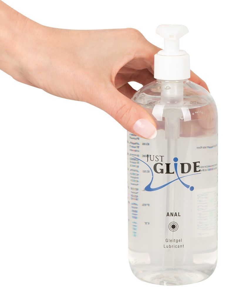 Transparente Flasche mit Dosierpumpe. Aufschrift: JUST GLIDE ANAL. Gleitgel. Hand hält die Flasche.