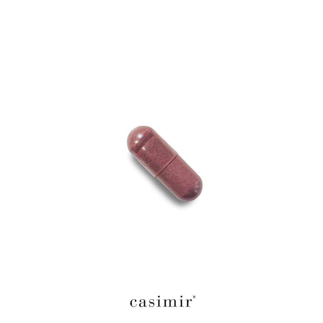 Eine einzelne, längliche Kapsel in Rosa-Braun. Auf weißem Hintergrund, mit "casimir" am unteren Rand.