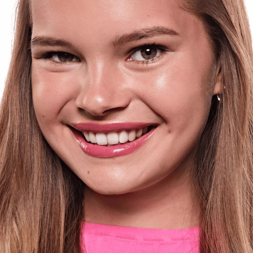 Porträt einer Frau mit rosa Lippen. Lächeln, Zähne sichtbar. Hautton hell.