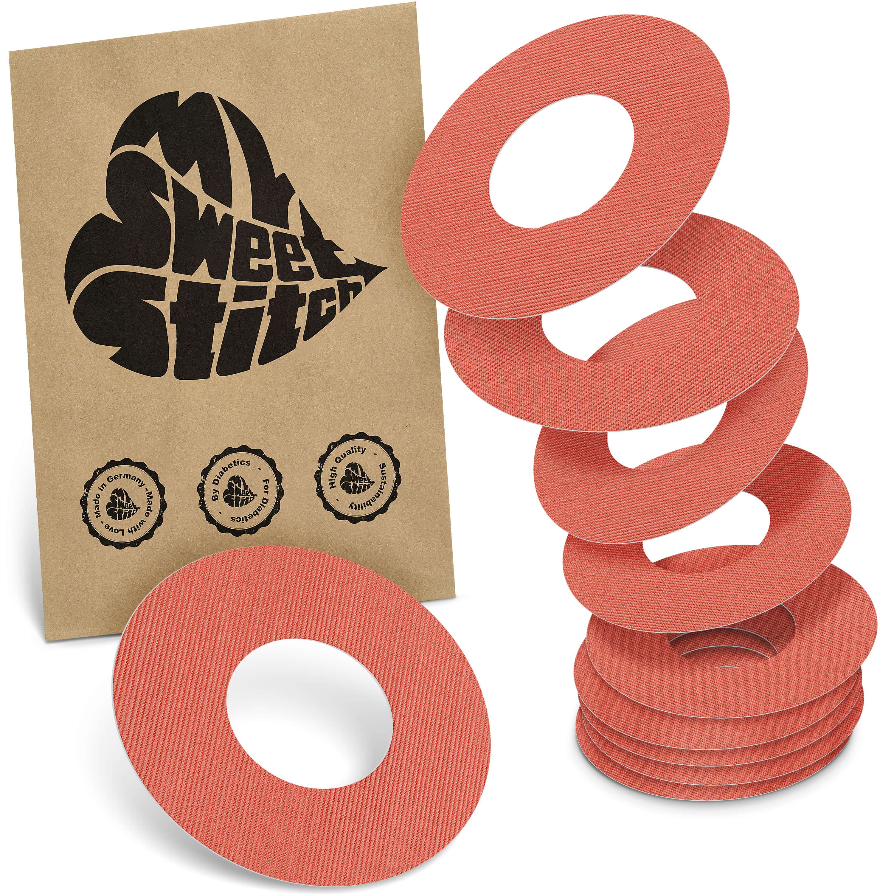 Ringförmige Pflaster in Lachsfarbe. Neben einer Papiertüte mit Logo liegen mehrere Pflaster. Auf der Tüte steht "My Sweet Stitch".